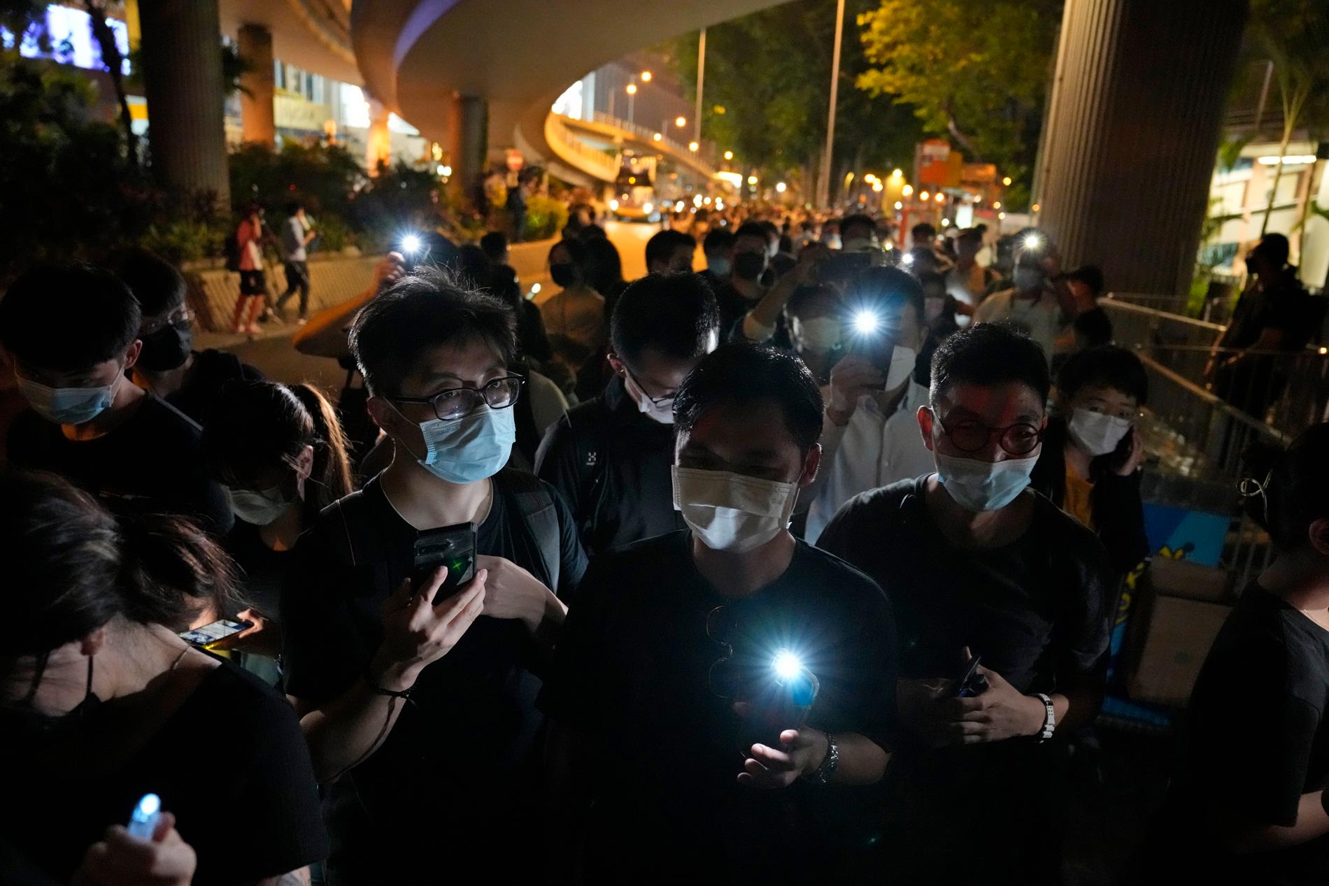 Människor som trots förbudet deltog vid en mindre minnesceremoni på årsdagen i fjol i Hongkong. Arkivbild.