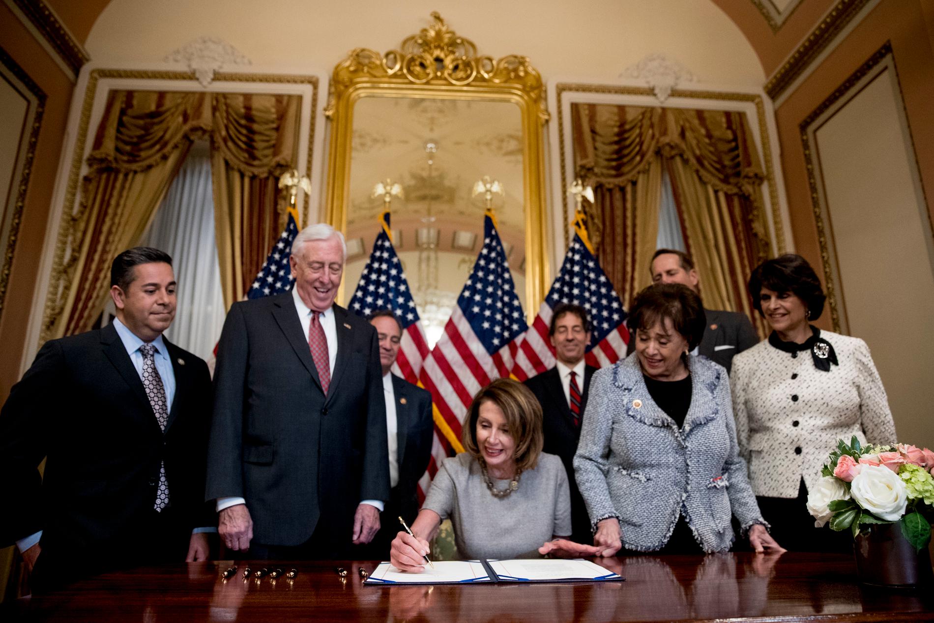 Representanthusets talman Nancy Pelosi (D), i nat när hon skrev under avtalet för att öppna den federala statsapparaten igen. 