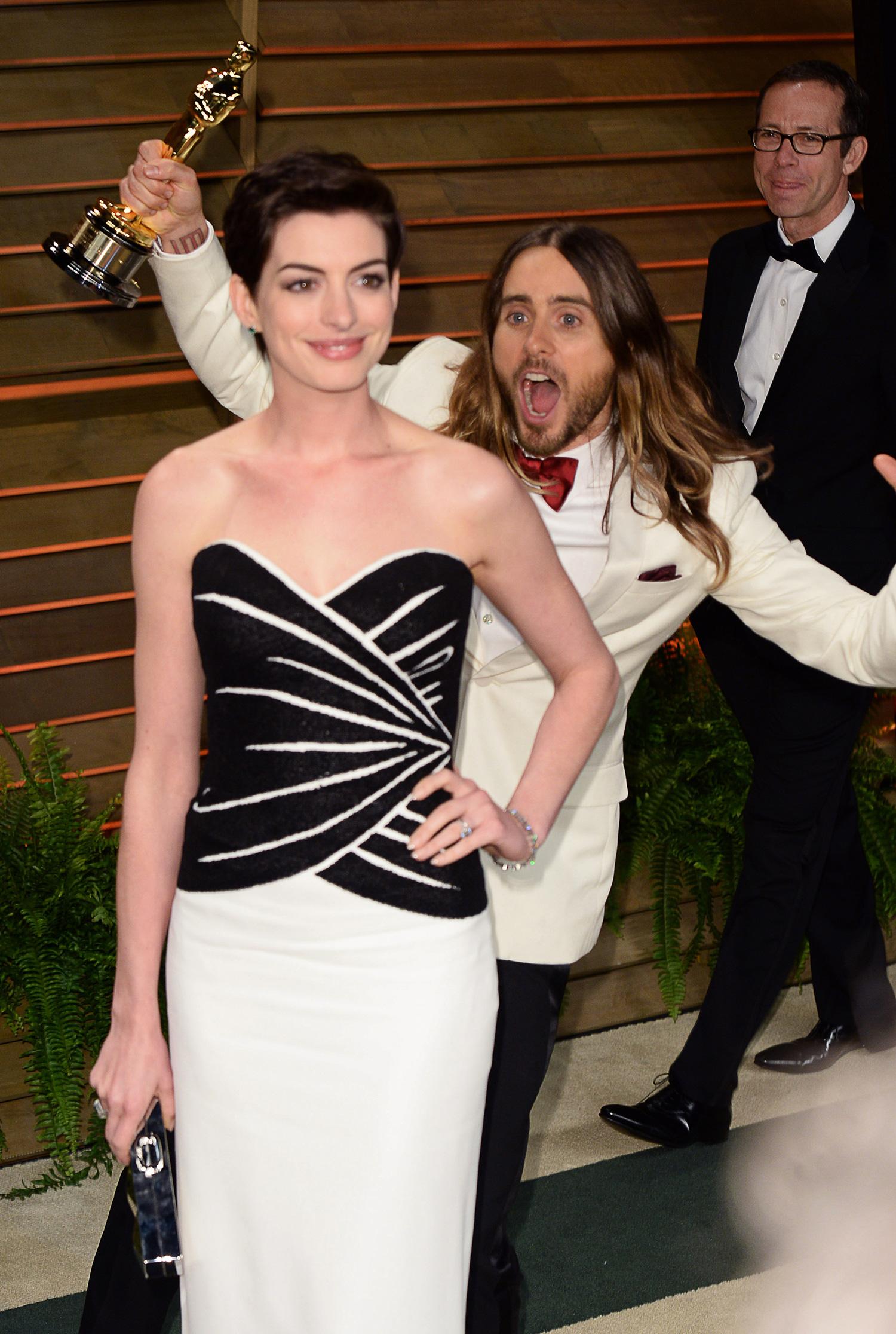 Här står Anne Hathaway och poserar. Helt ovetandes om att det står en galen Jared Leto bakom henne.
