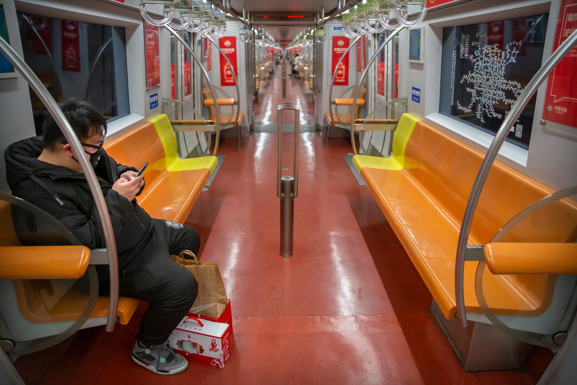 En ensam resenär på en i vanliga fall full tunnelbanelinje i Peking.