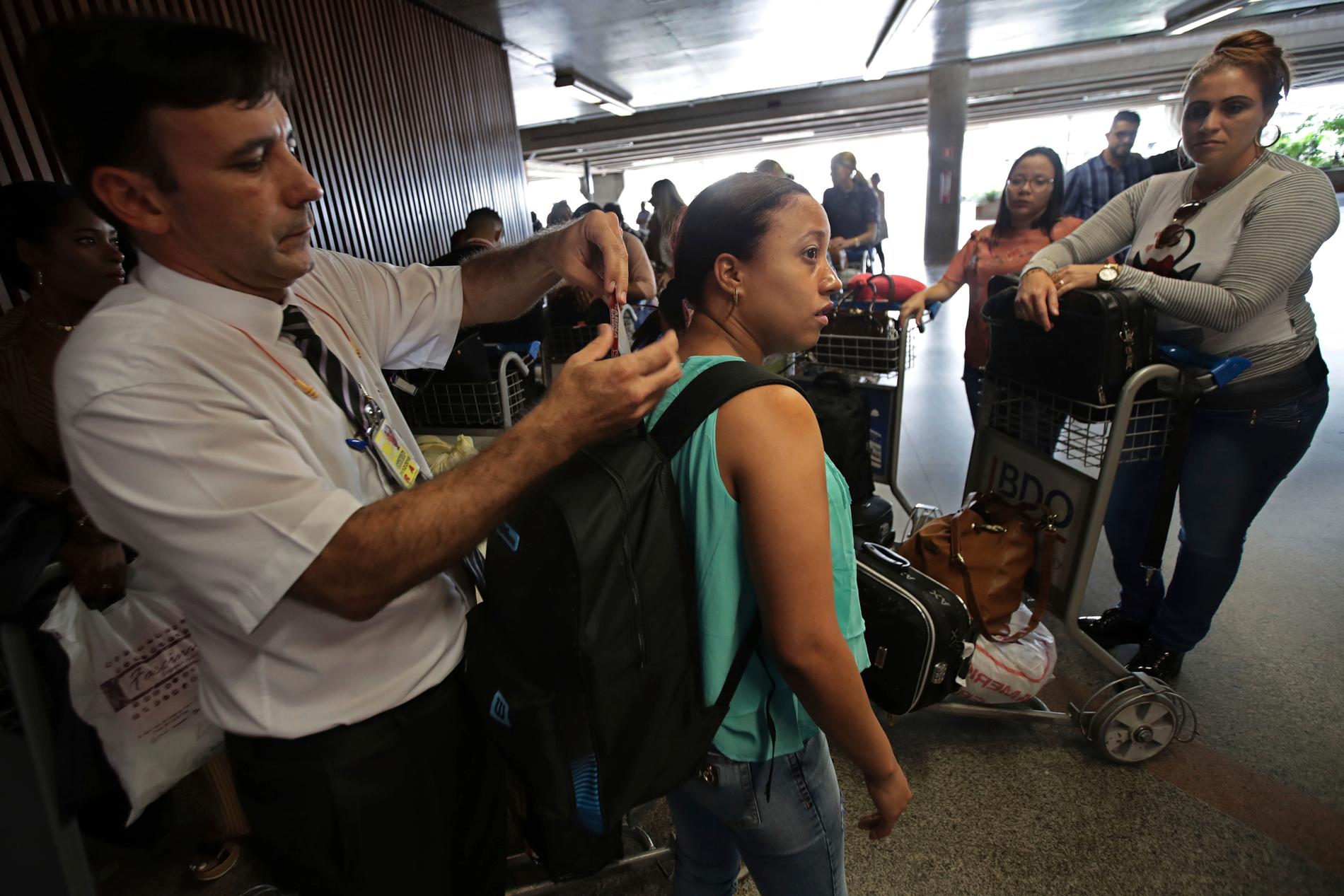 En läkare får sitt bagage taggat på Brasílias flygplats, inför hemfärden till Kuba.