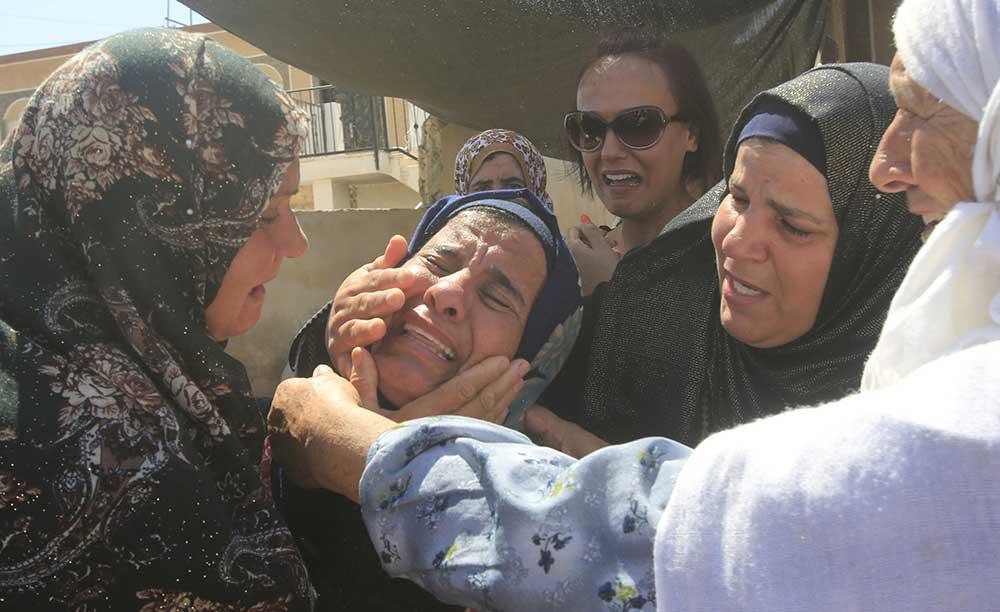 En släkting skriker ut sin sorg vid Saad Dawabsheh begravning i byn Duma.