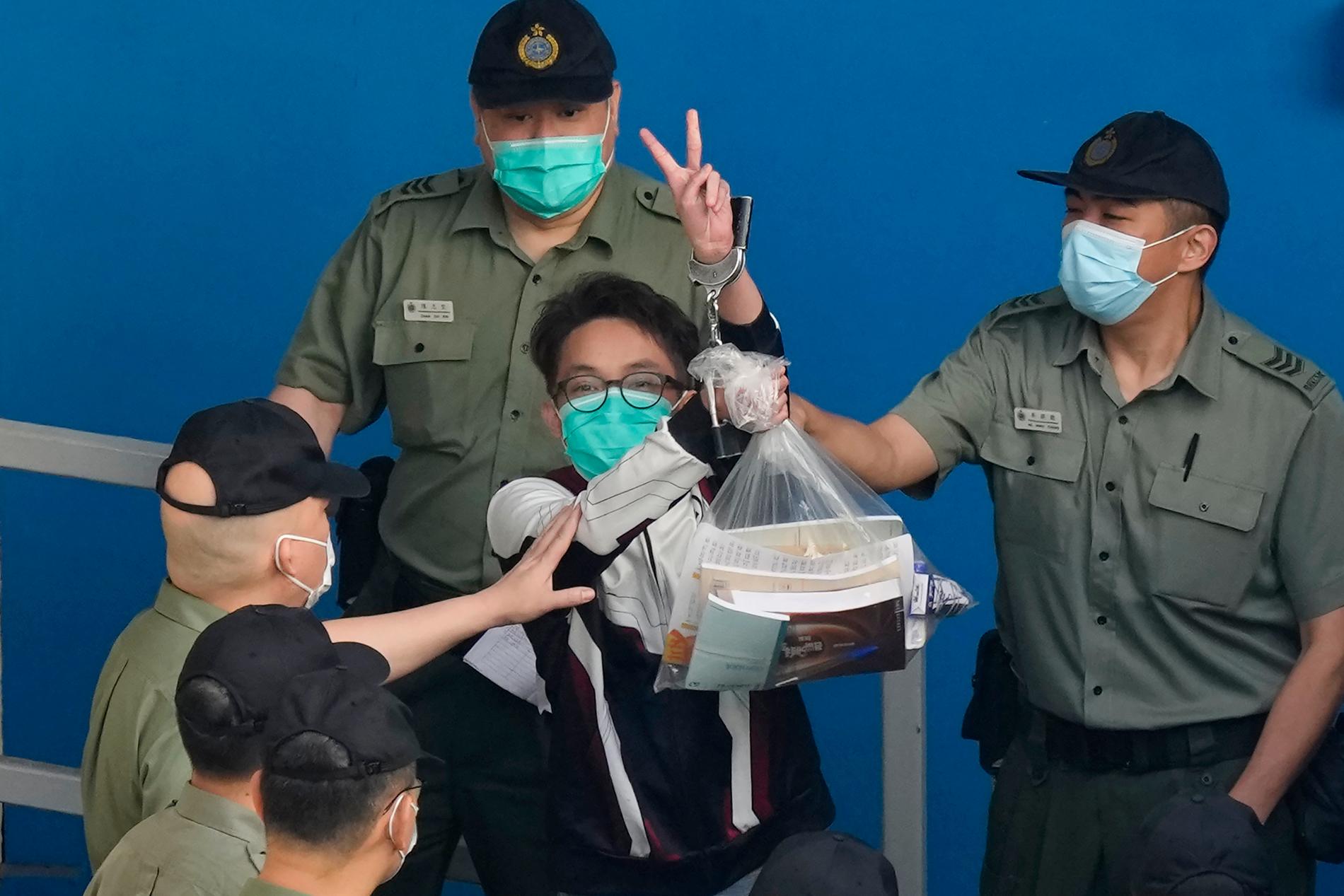 Demokratiaktivisten Figo Chan eskorteras av vakter.