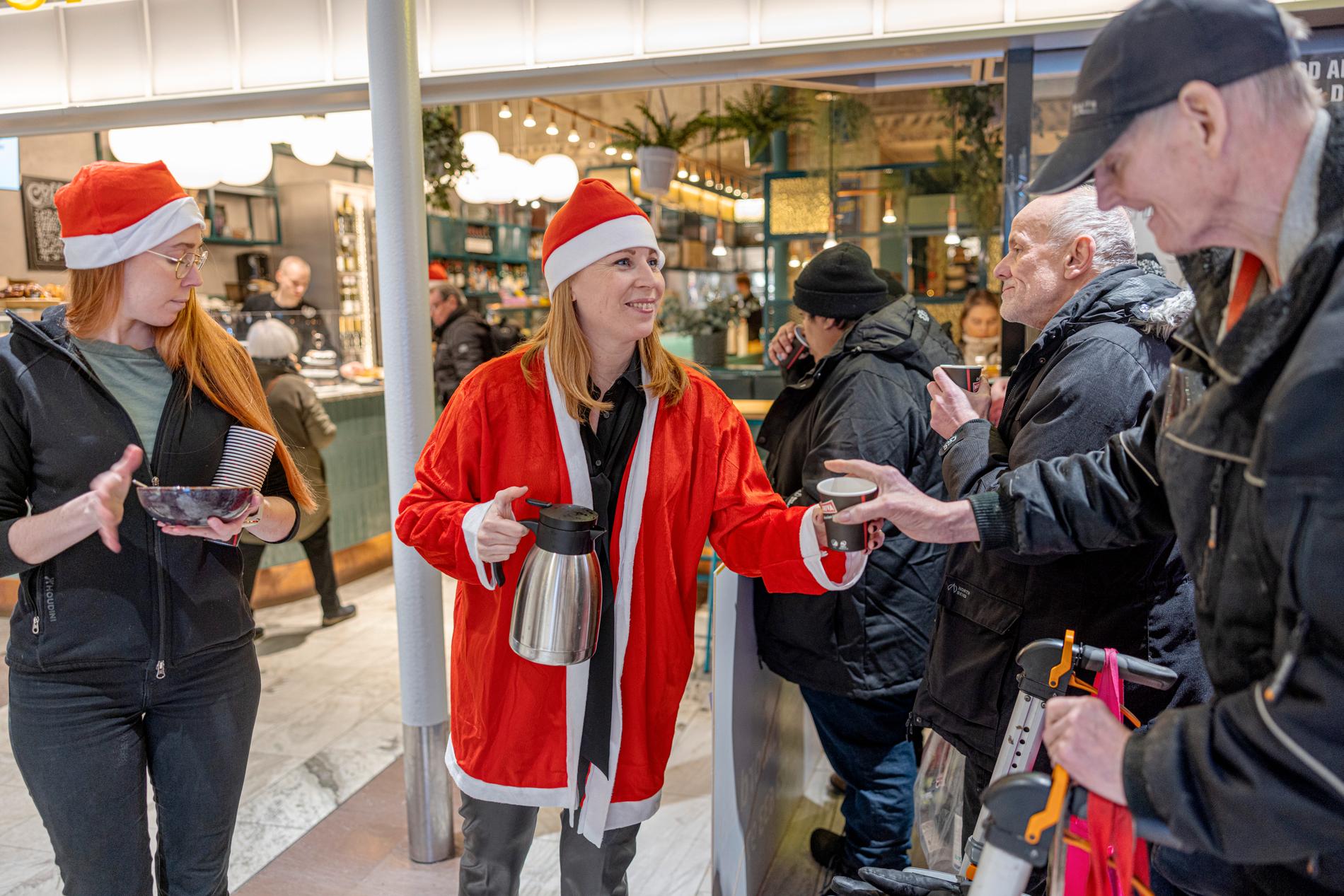 Centerpartiets partiledare Annie Lööf  serverade glögg till gästerna. Närmast i bild får pensionären Rolf en kopp. 