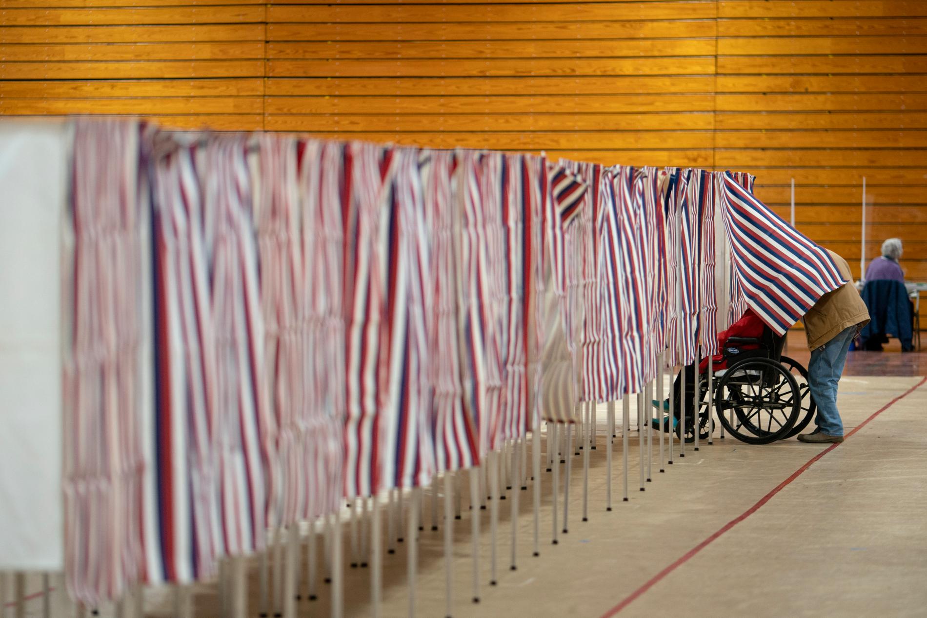 En väljare lämnar en bås efter att ha lagt en omröstning i presidentvalet i New Hampshire.