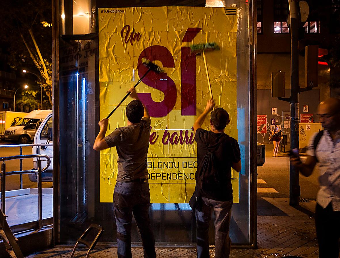 Barcelonabor klistrar upp affischer om valet i morgon. Den spanska regeringen har förbjudit spridande av information och reklam för folkomröstningen.