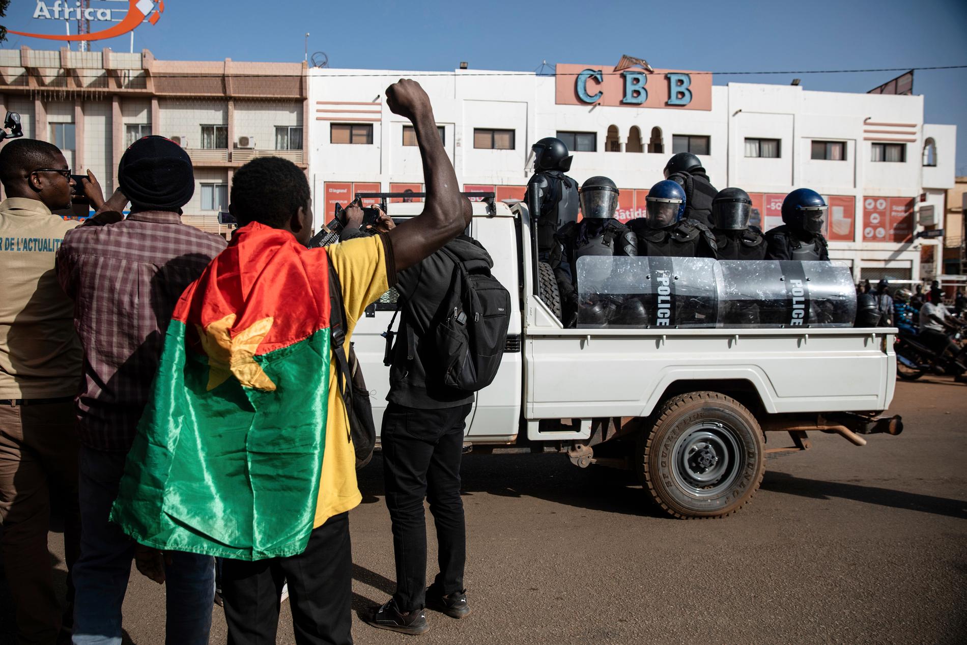 Demonstranter på Ouagadougous gator i lördags, övervakade av kravallpoliser.