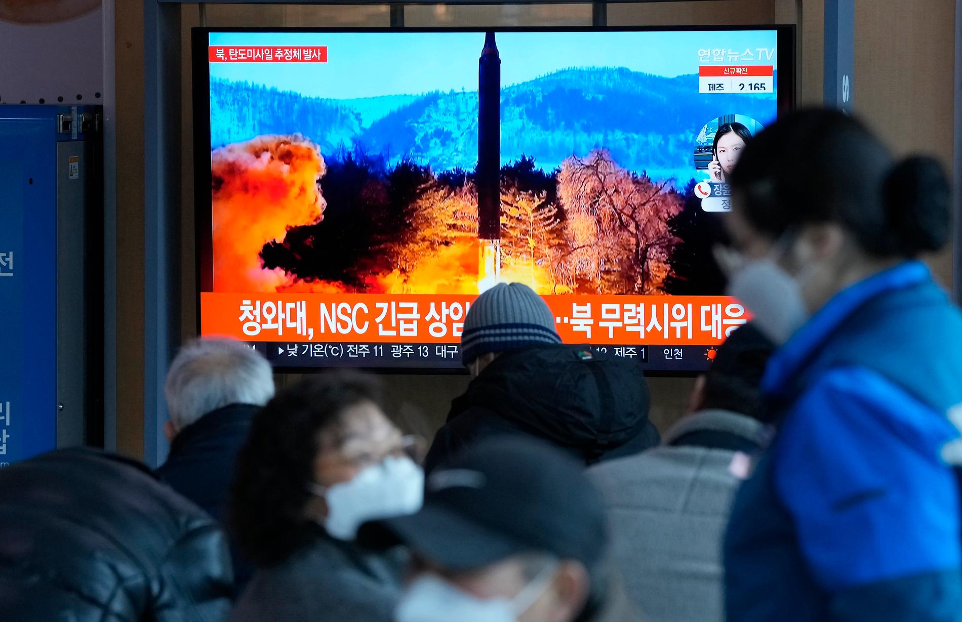 Människor i Sydkorea följer uppskjutningen på en tv-skärm.