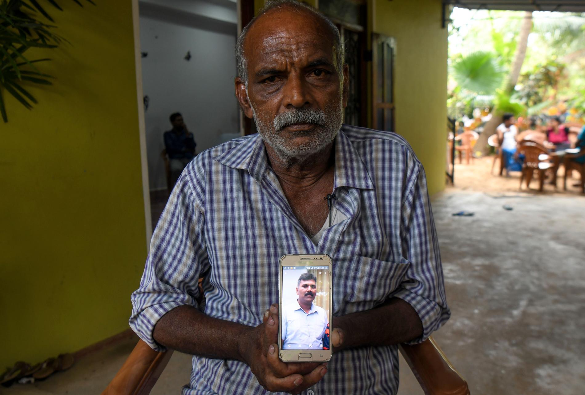 Velusami Raju, Ramesh Rajus pappa, håller upp en bild på sonen. 