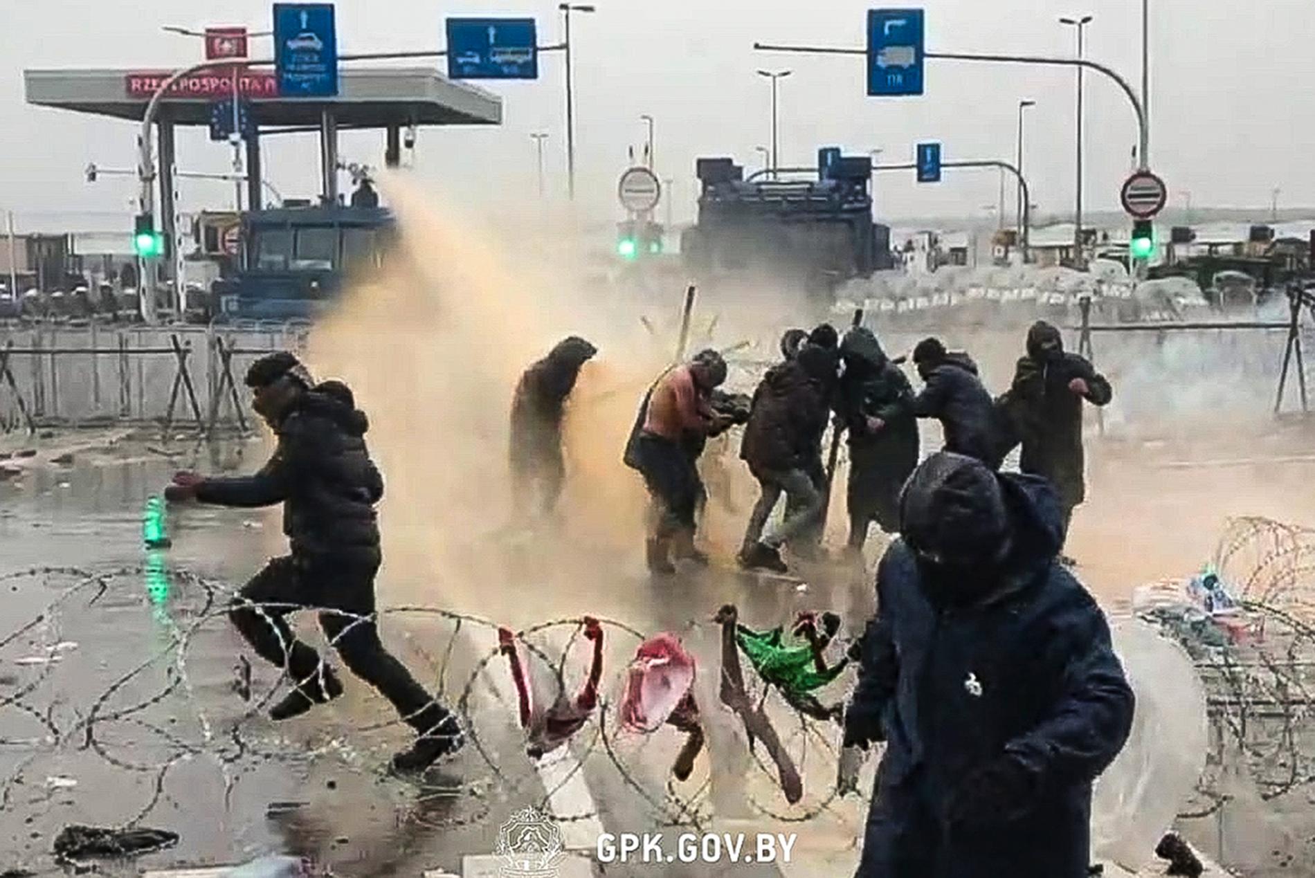 En handoutbild från Belarusiska myndigheterna visar hur migranter möts av vattenkanoner när de närmar sig den polska gränsen. 
