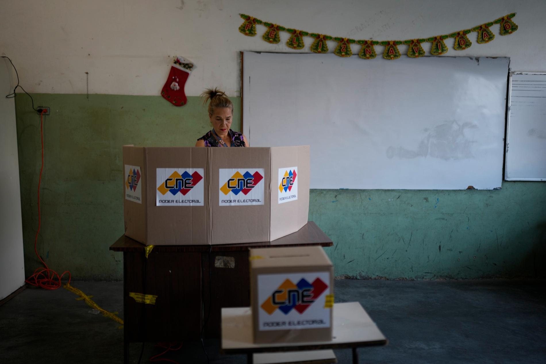 En kvinna i Venezuelas huvudstad Caracas lägger sin röst i folkomröstningen om Essequibo.
