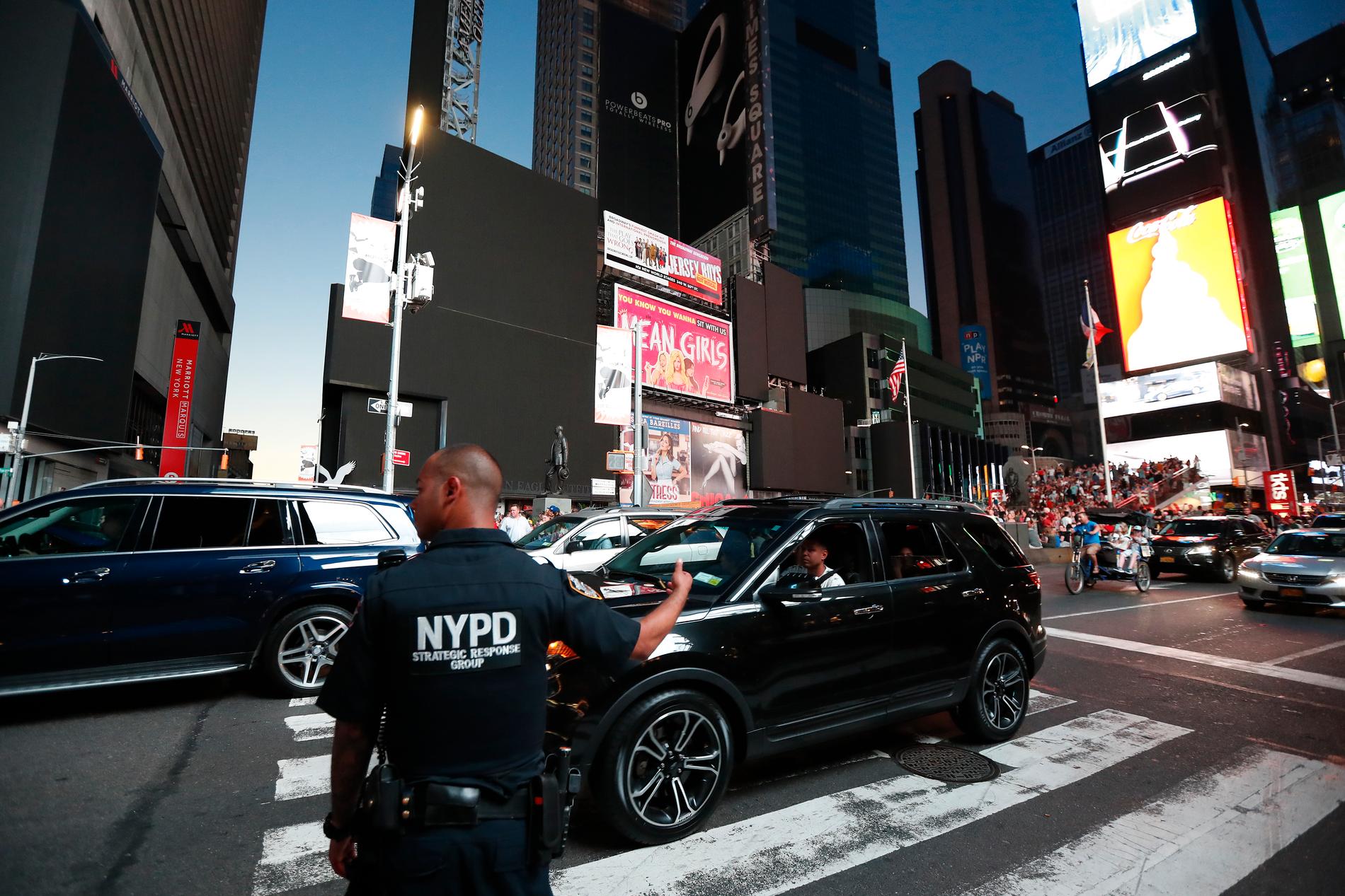 En polis dirigerar om trafiken på Manhattan efter att trafikljusen slagits ut i ett strömavbrott.