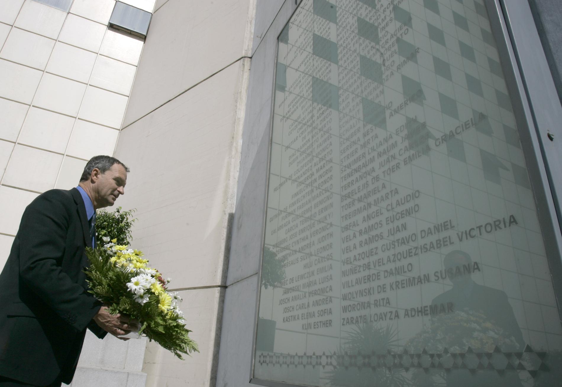 En judisk politiker håller en blombukett vid minnesmärket i Buenos Aires för attentatet mot en judisk inrättning där 85 människor dödades 1994. Arkivbild.