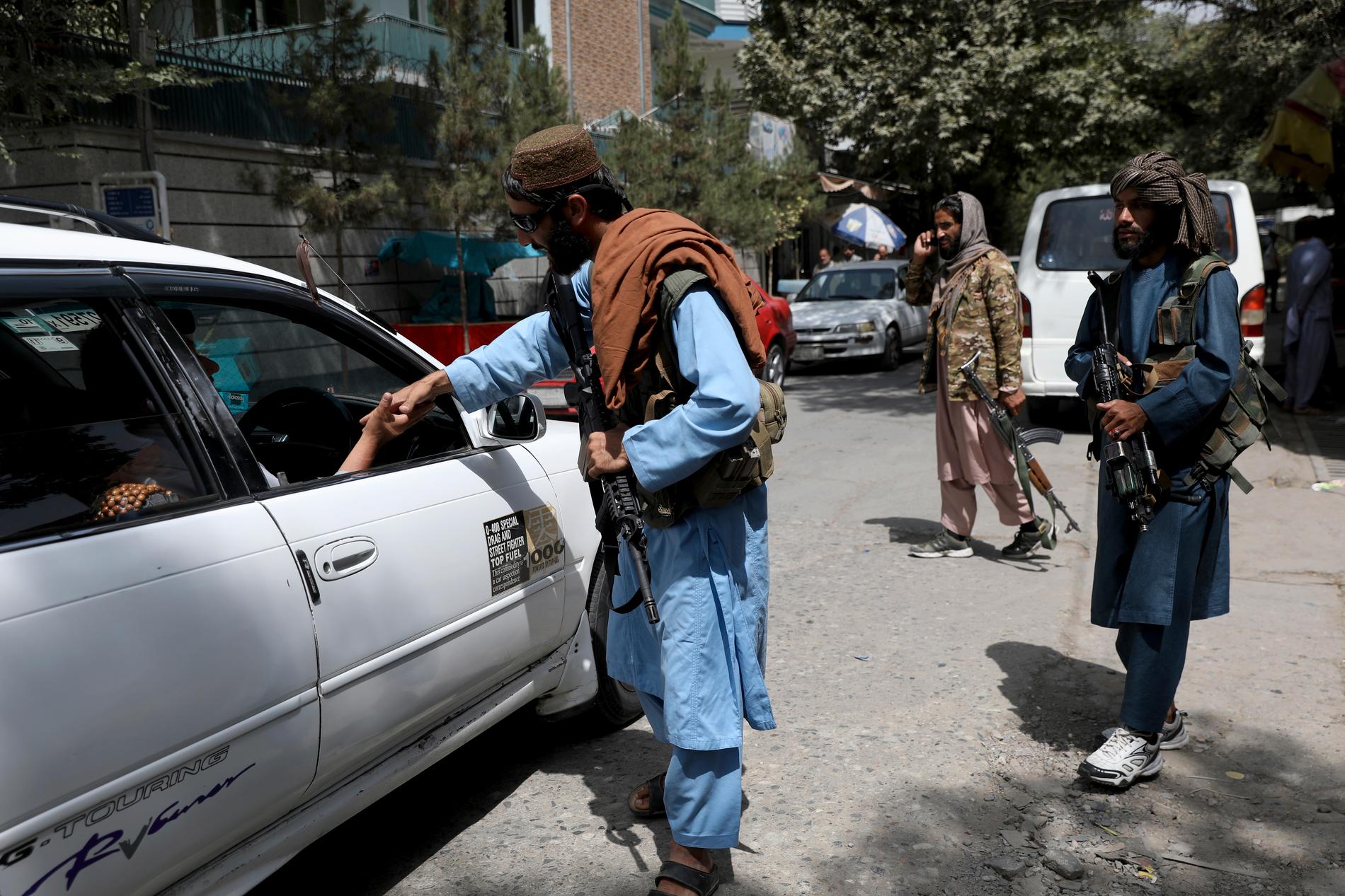 Talibaner kontrollerar passerade fordon vid en checkpoint i Kabul.