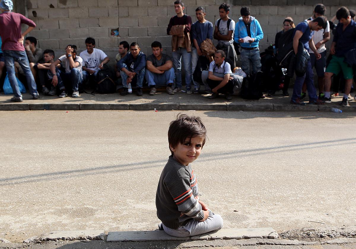 Presevo, Serbien: En ung pojke väntar ensam på att få mat tillsammans med hundratals andra flyktingar i serbiska staden Presevo.