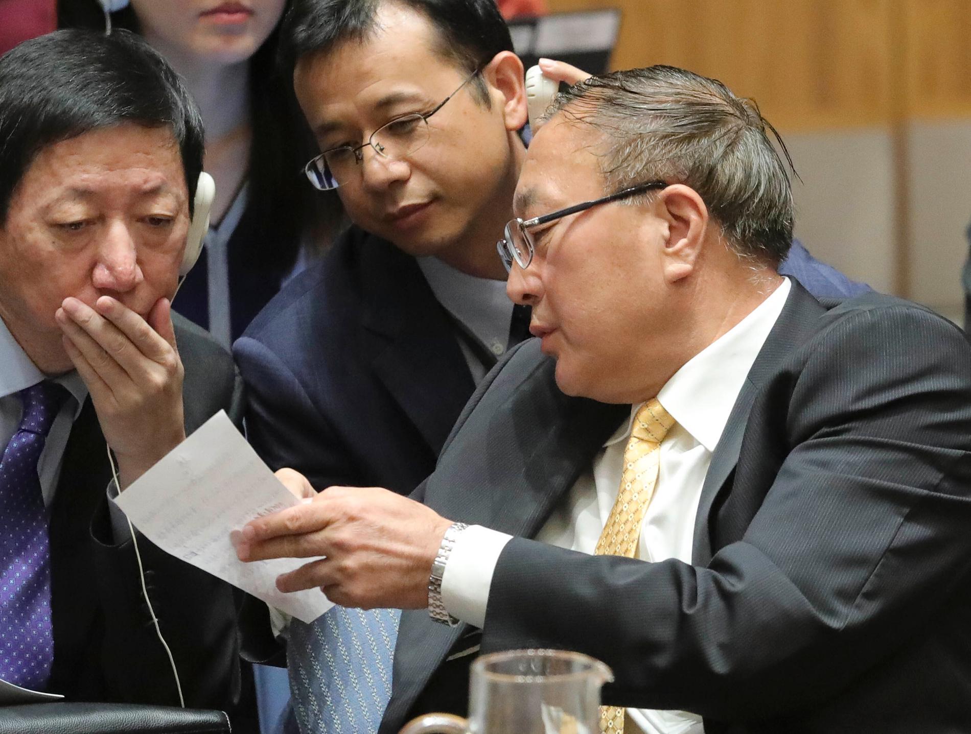 Kinas FN-ambassadör Zhang Jun (till höger) överlägger med sina medarbetare under säkerhetsrådets möte om Syrien.