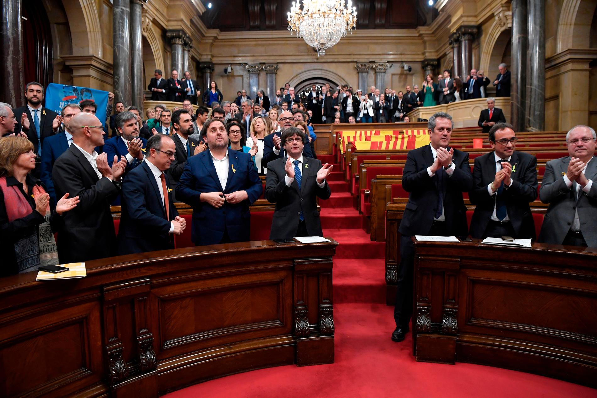 Kataloniens president Carles Puigdemont applåderar efter omröstningen.