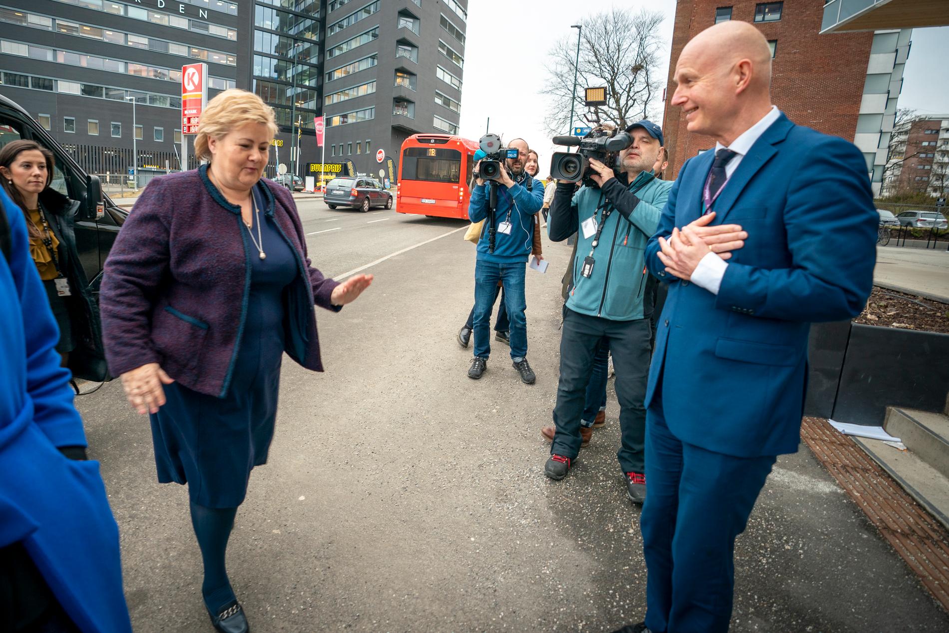 Norges statsminister Erna Solberg och chefen för det norska helsedirektoratet Bjørn Guldvog hoppar över handhälsning vid ett möte under torsdagen
