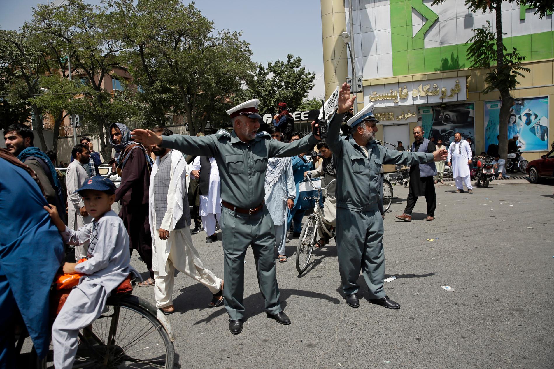 Afghanska poliser gör vägen fri för talibanerna som patrullerar i Kabul. 
