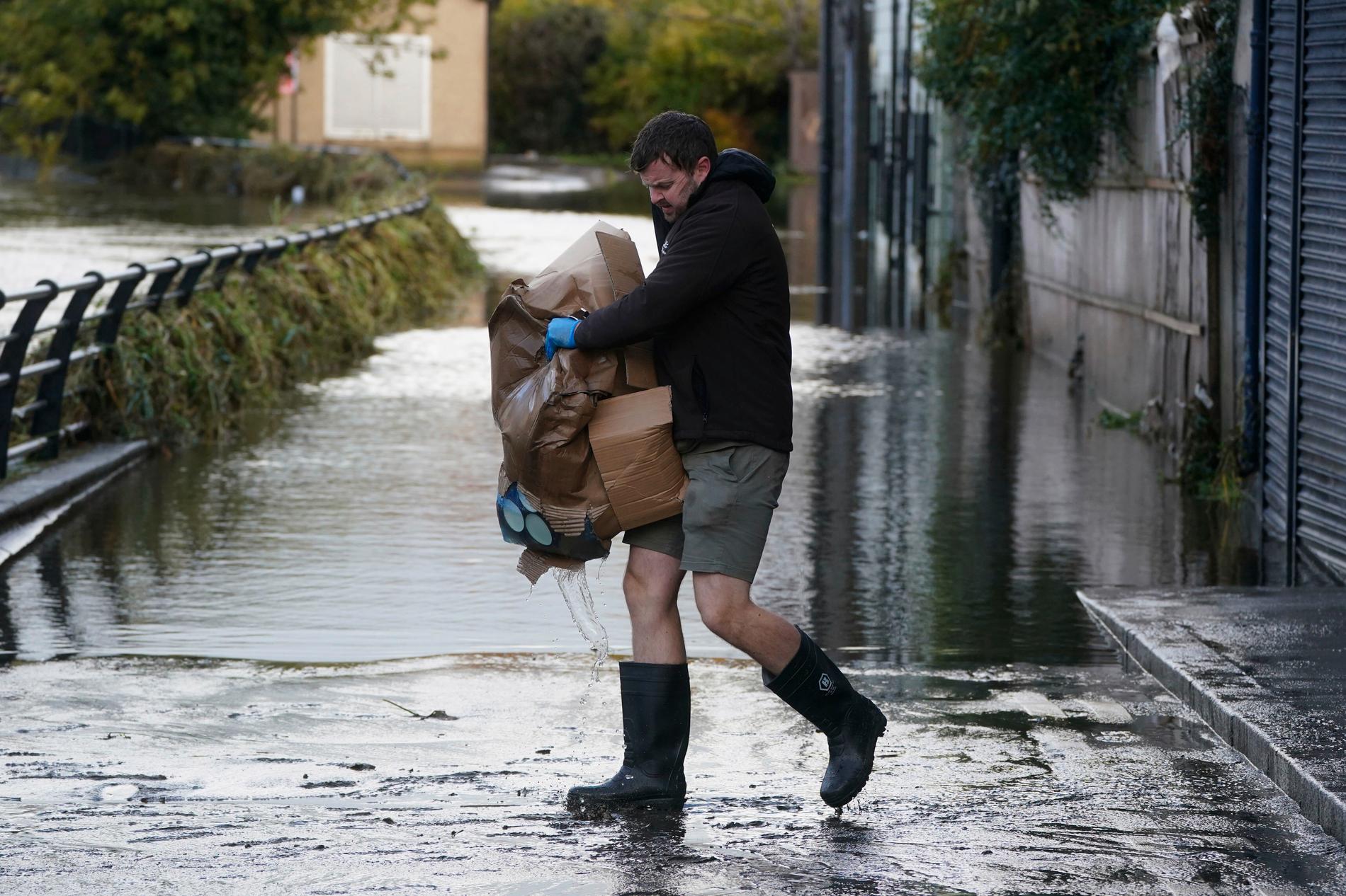 En man i Newry Town i Nordirland förbereder sig inför de regn som ovädret Ciarán tros föra med sig.