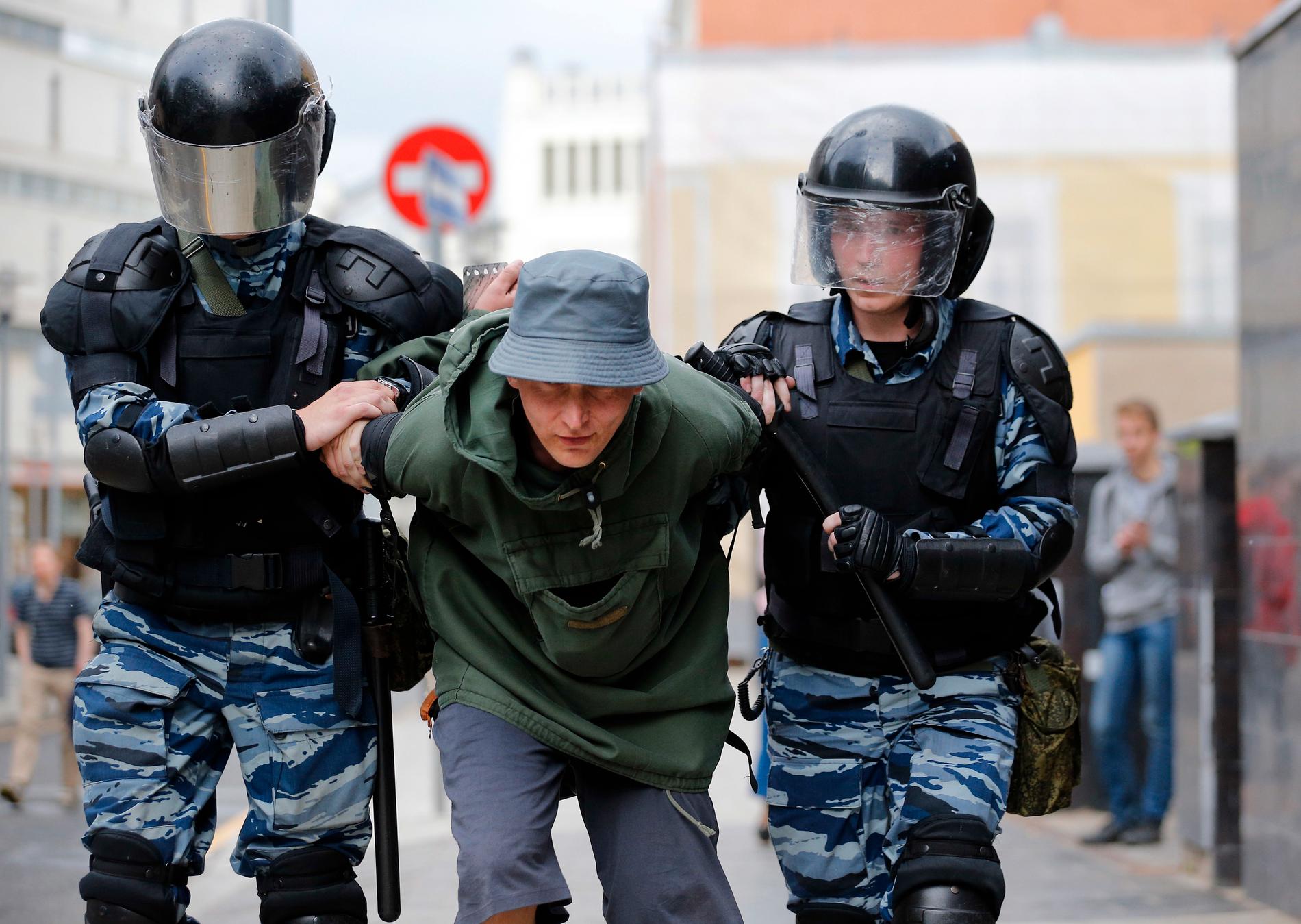En man förs i väg av polisen i Moskva i samband med protesterna.