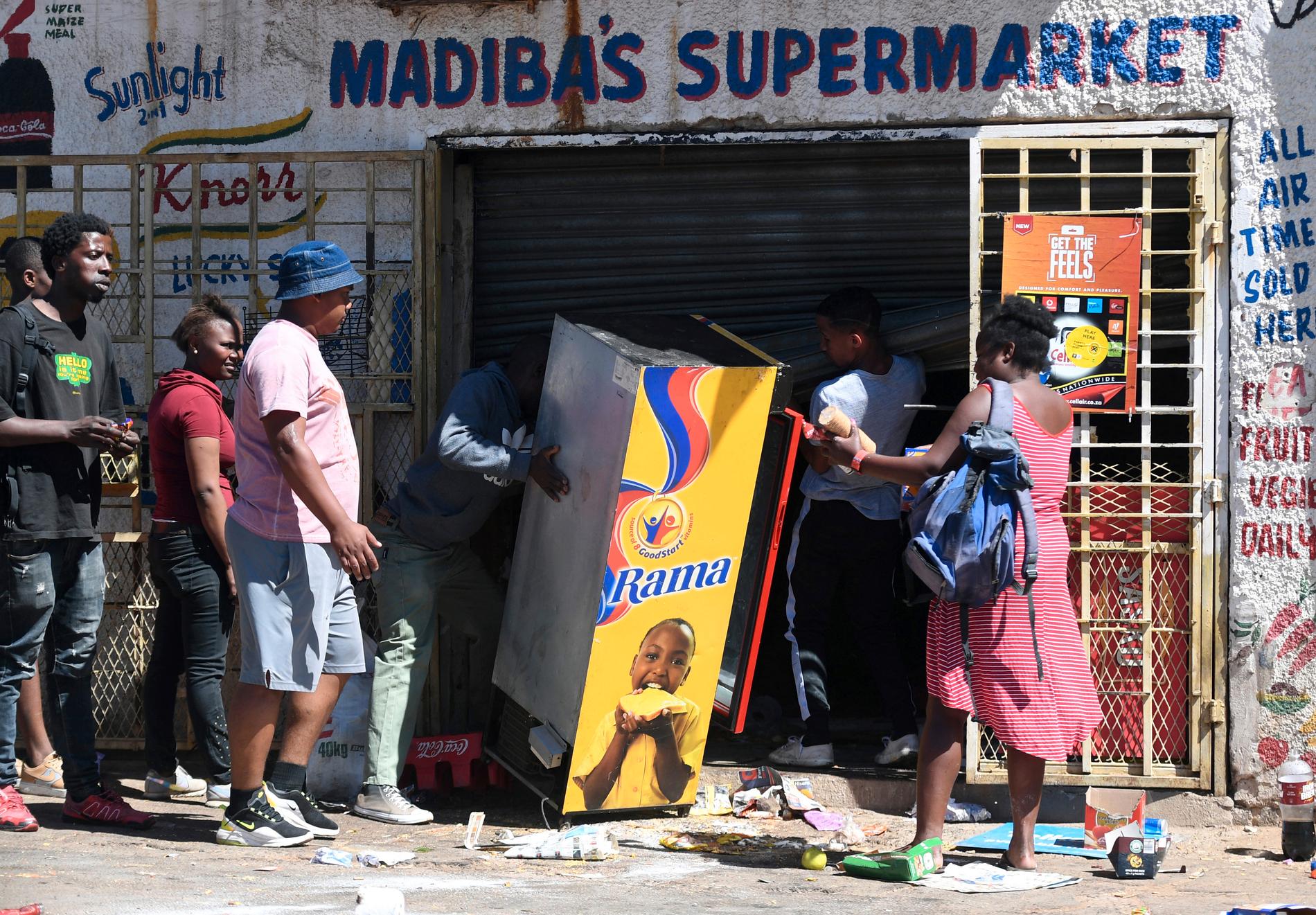 Plundrare vid en förstörd butik i utkanten av den sydafrikanska staden Johannesburg. Arkivbild.