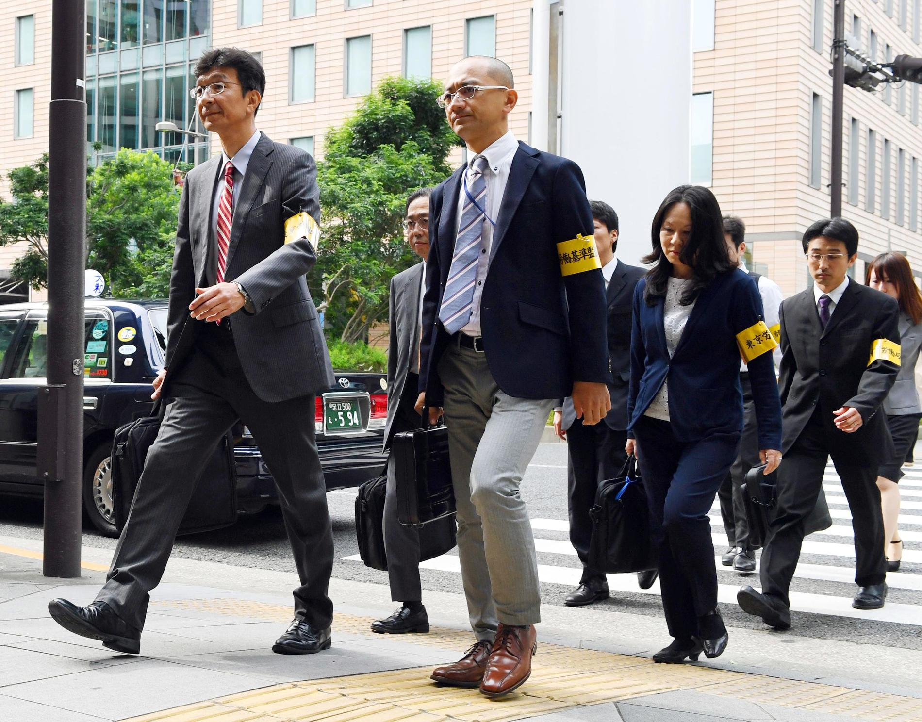 Inspektörer på väg in på en reklambyrå i Tokyo efter ett uppmärksammat självmord 2016. Det fallet, liksom många andra i Japan, ansågs bero på att folk pressas för hårt i arbetslivet.