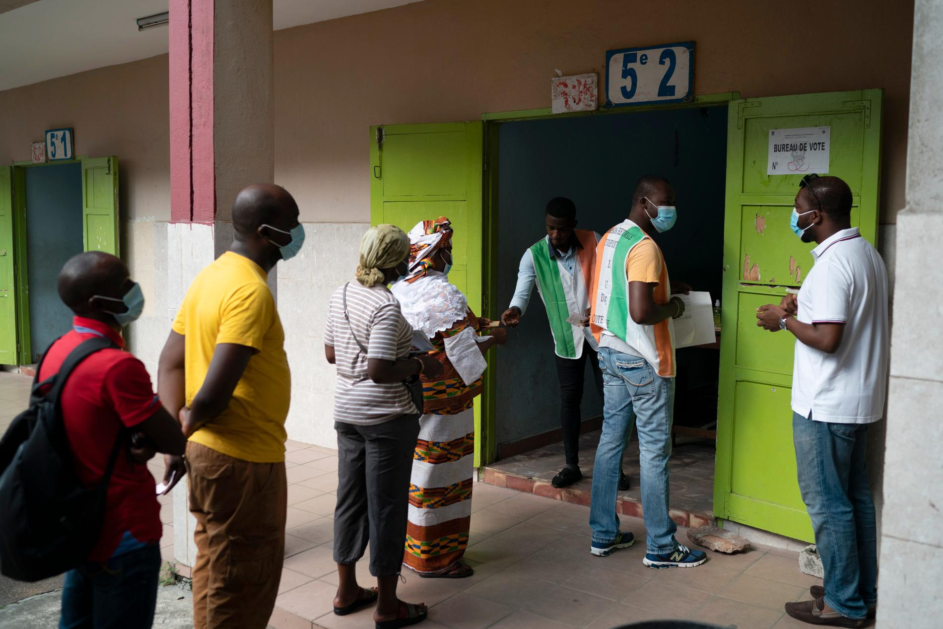 Folk köar för att komma in i en vallokal i Abidjan, Elfenbenskusten.