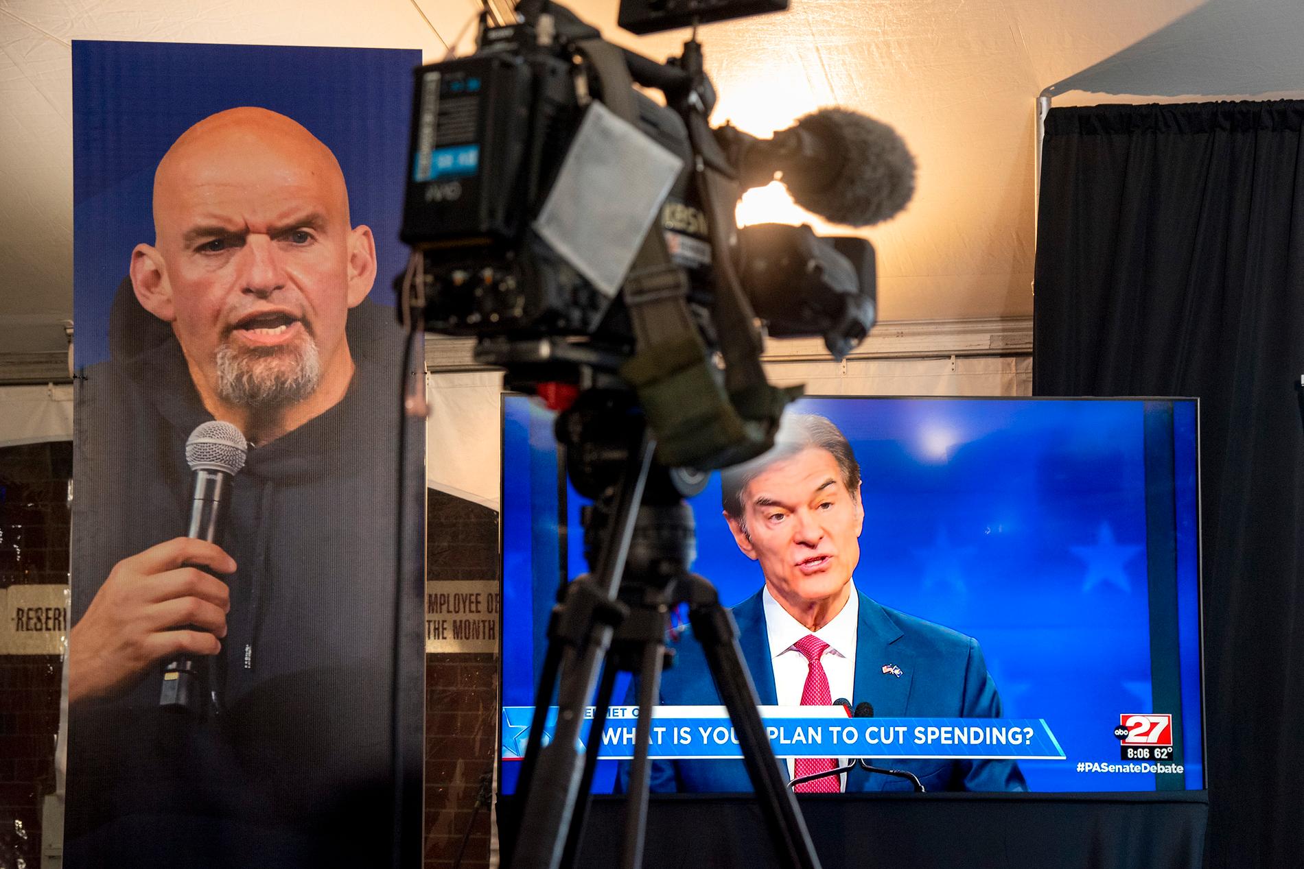 Demokraten John Fetterman, på affischen till vänster i bild, och republikanen Mehmet Oz, på tv-skärmen. De två Pennsylvania-politikerna gör upp om en väldigt viktig plats i den amerikanska senaten.