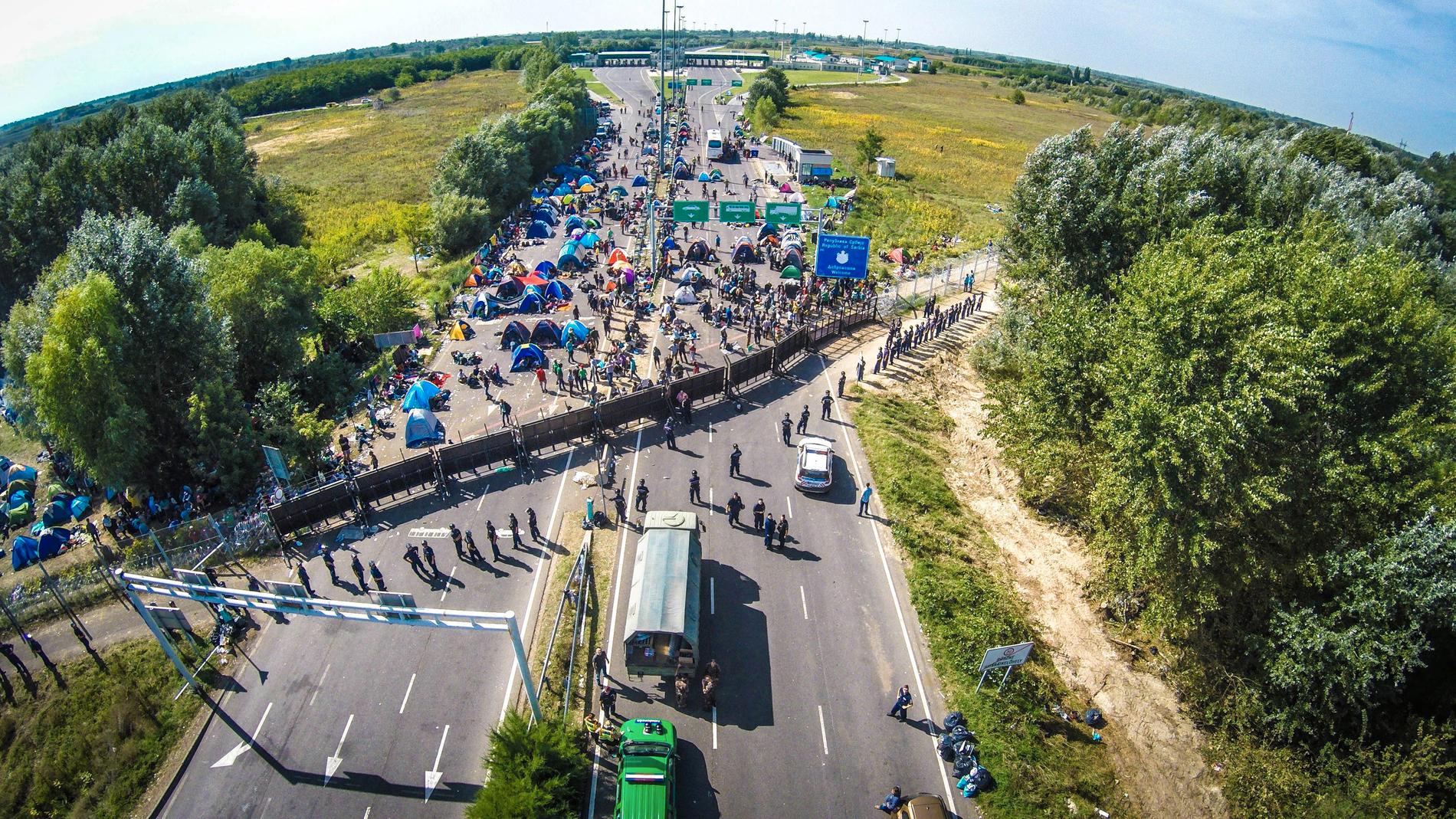 Här syns strandade migranter vid gränsen mellan Serbien och Ungern.