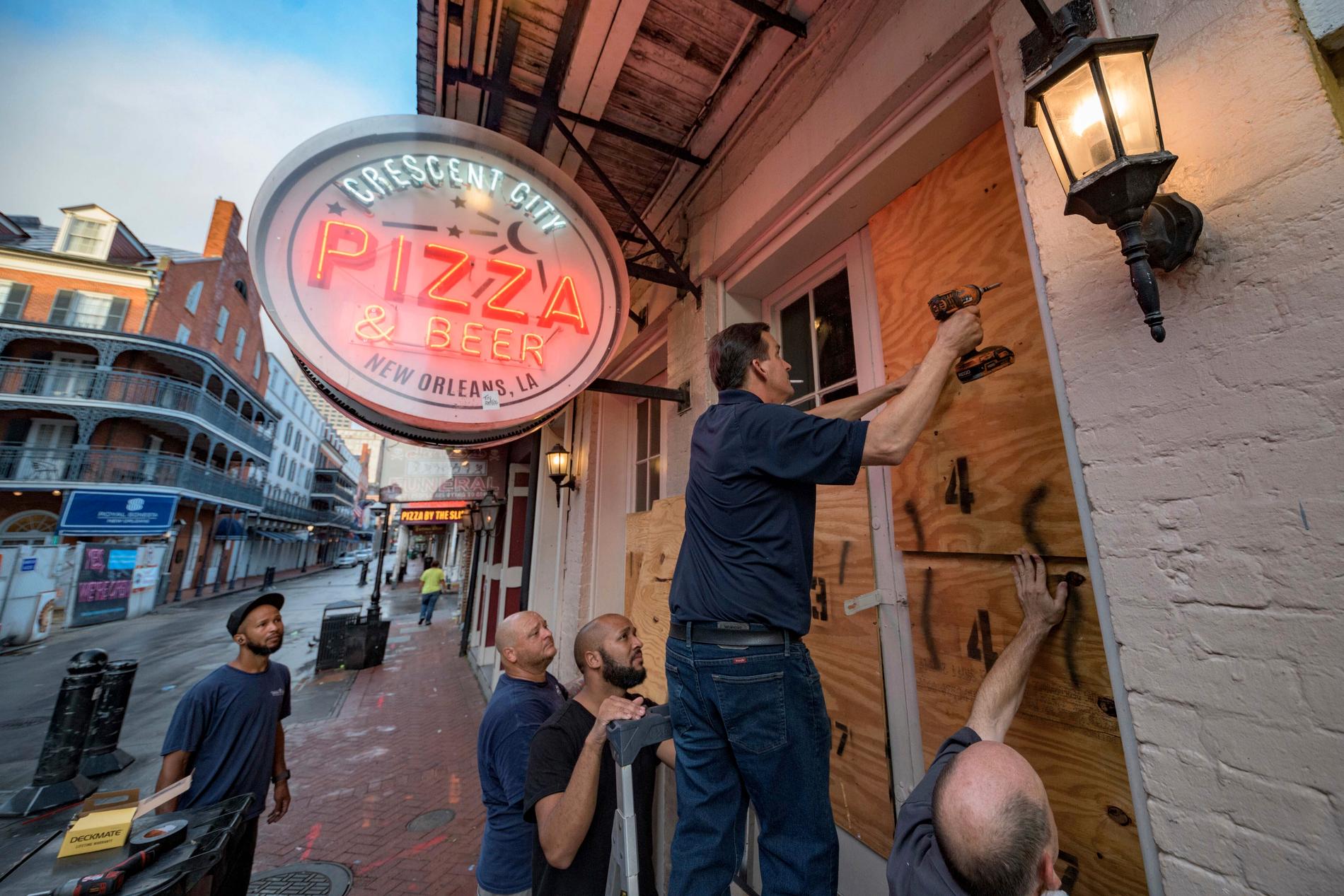 Personal på en pizzeria i New Orleans stormsäkrar lokalen inför orkanen Idas ankomst.