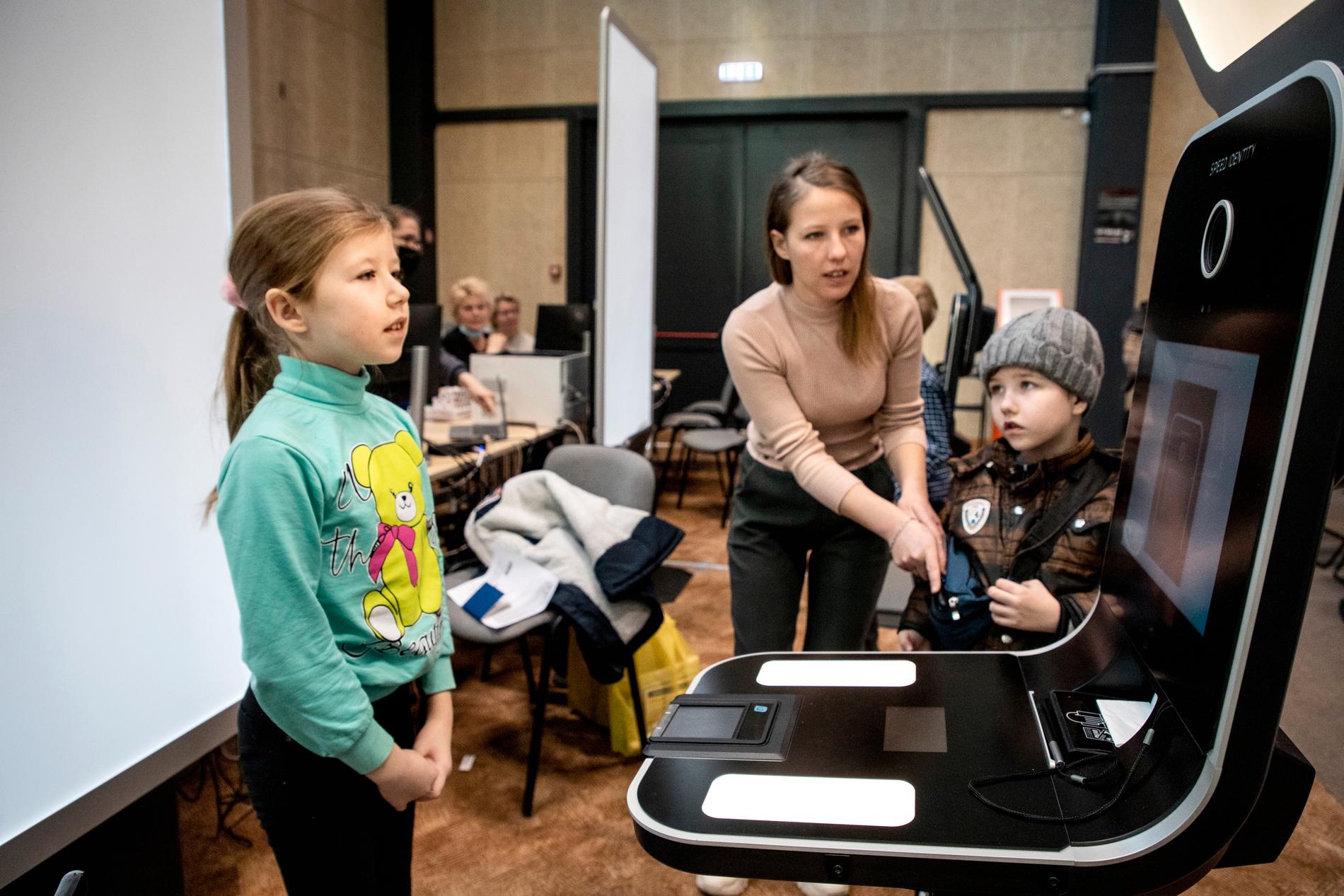 Larissa hjälper dottern Anna, 9 år och sonen Nikita 7 år att fotograferas för att kunna registreras i Litauen. Hela familjen har just anlänt från Odessa till Röda Korsets center i Vilnius.