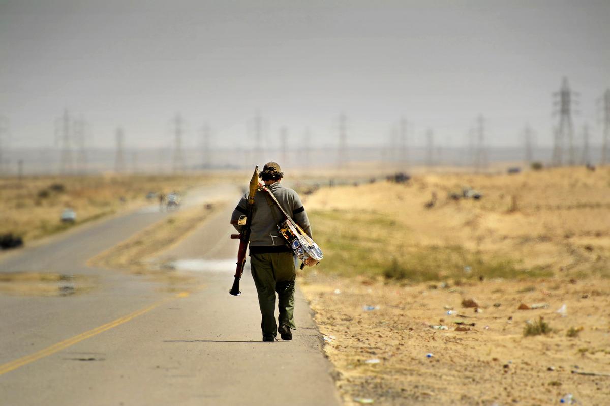 FOLKETS KRIG Mitt i öknen utanför staden Ajdabiya där Libyens folk kämpar för sin frihet mot Gaddafis legosoldater kommer en man gående. På ena axeln bär han en gitarr, på den andra ett granatgevär. ”Peace” ropar han till Aftonbladets team innan han fortsätter mot fronten.
