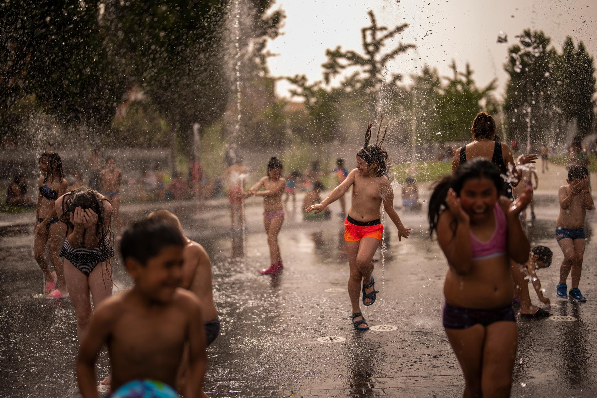 I Madrid svalkar sig människor i en fontän när temperaturerna häromdagen nådde 43 grader. 