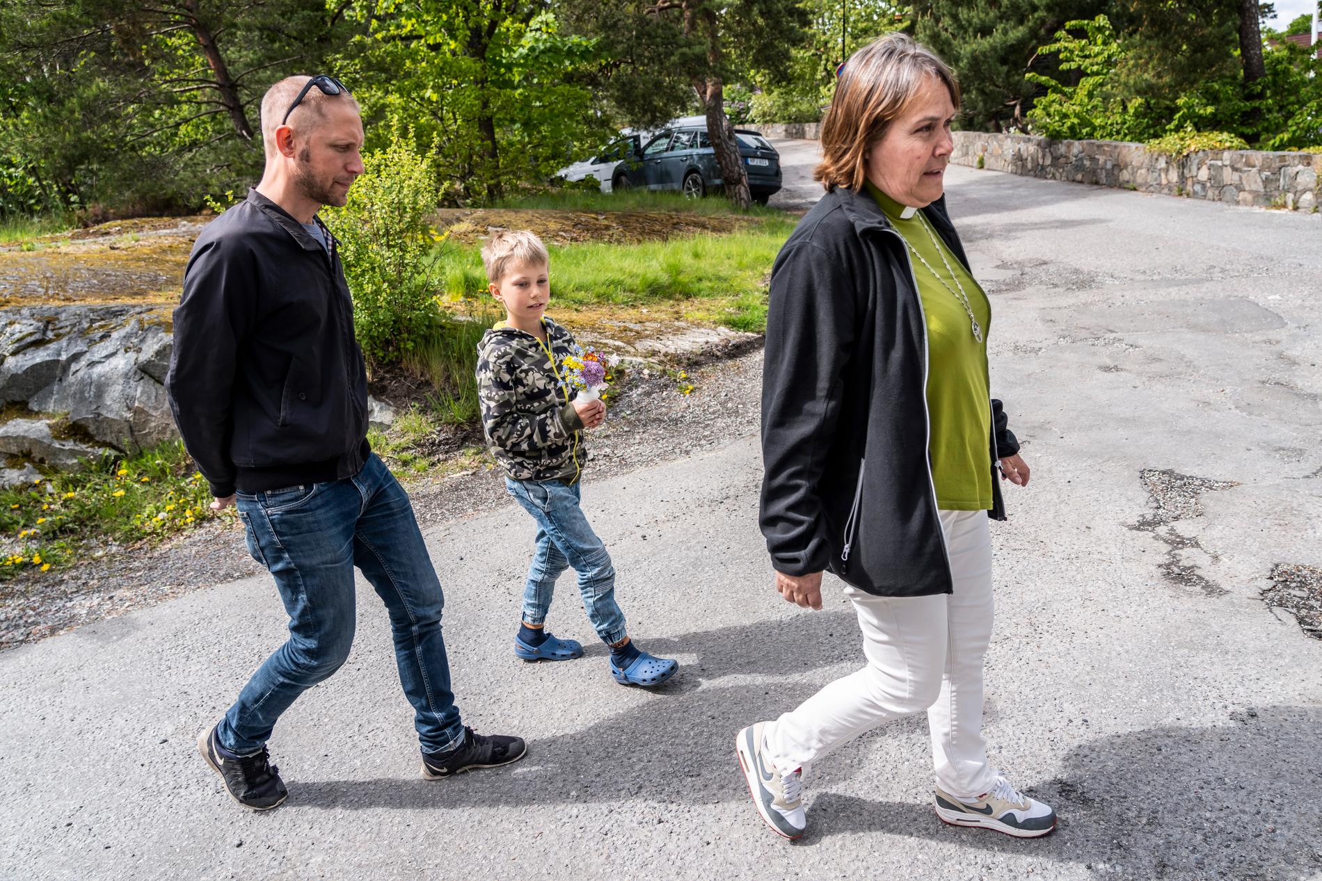 Erik, 8, besöker kyrkan med sin pappa. Till höger Karin Österby som är diakon i Hägerstens församling.