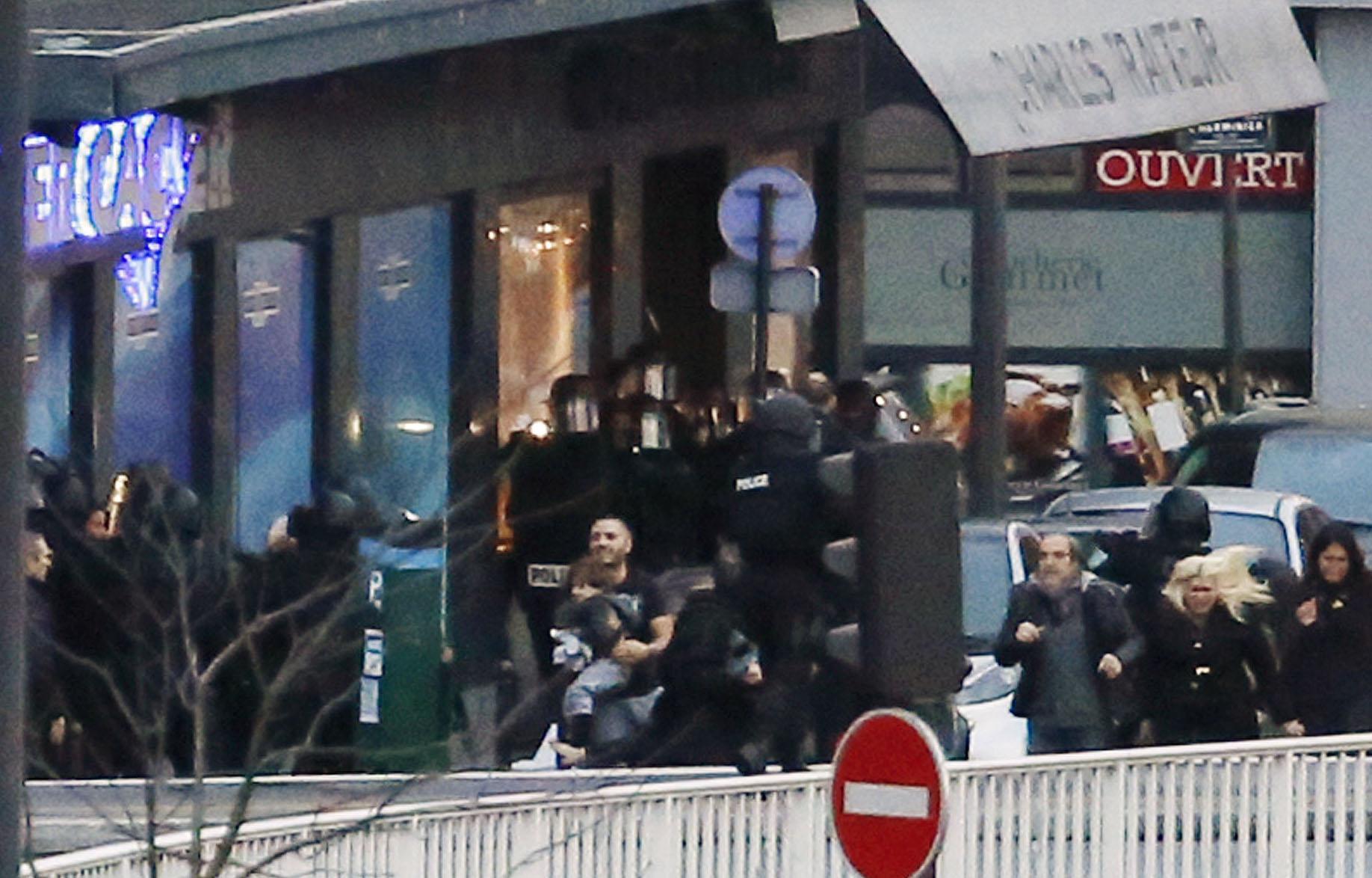 Polis evakuerar gisslan ur butiken i Paris.