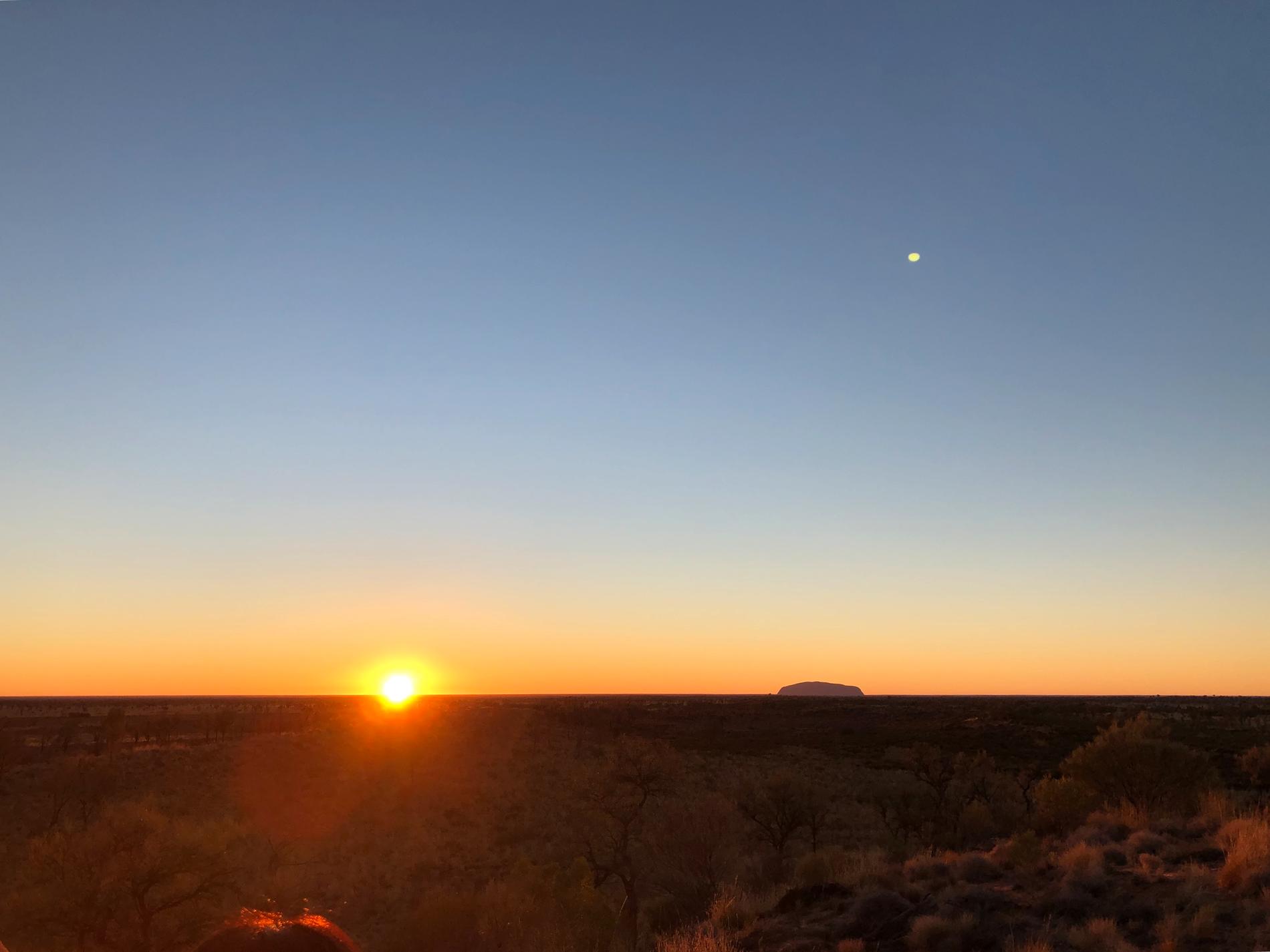 Uluru (Ayers Rock) utmärker sig på många mils håll i det platta ökenlandskapet i centrala Australien. Här fotograferad i soluppgången en kall vintermorgon.