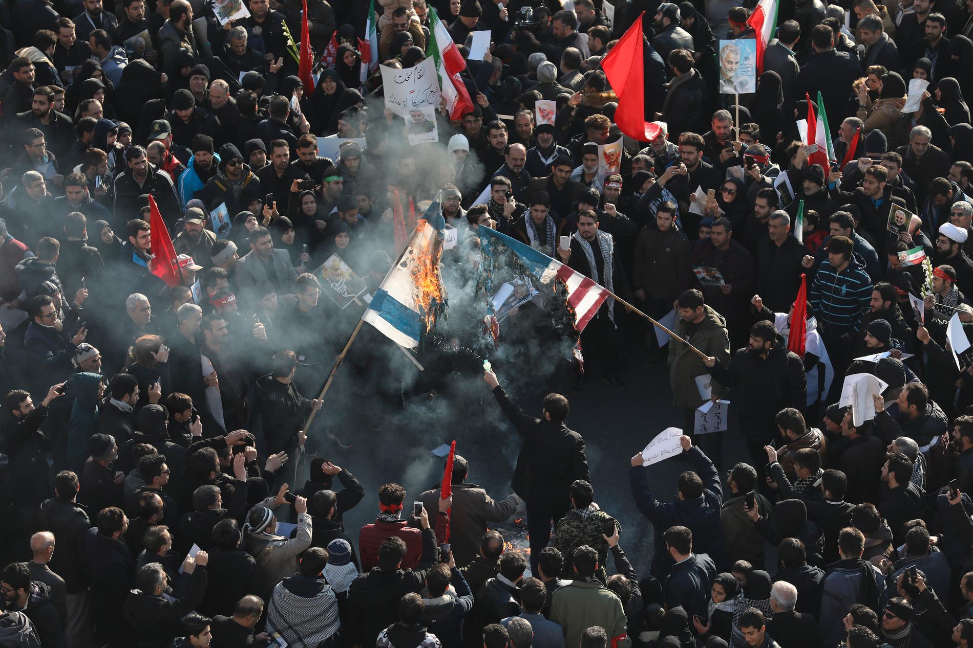 Israels och USA:s flagga bränns i folksamlingen i Teheran.