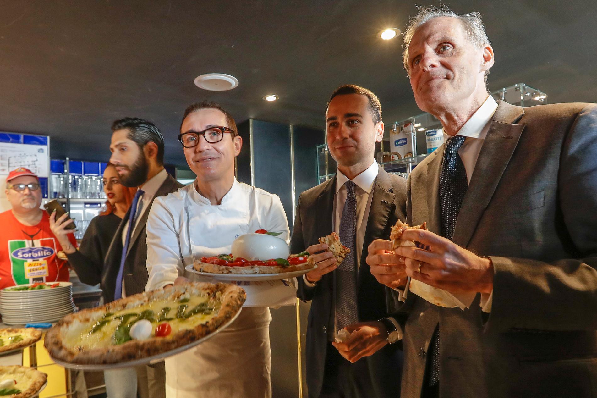 Italiens utrikesminister Luigi Di Maio, i mitten, äter pizza tillsammans med Frankrikes Romambassadör Christian Masset. Di Maio bjöd in ambassadören till pizzalunch sedan en fransk tv-kanal sänt ett kritiserat satirinslag om "coronapizza".