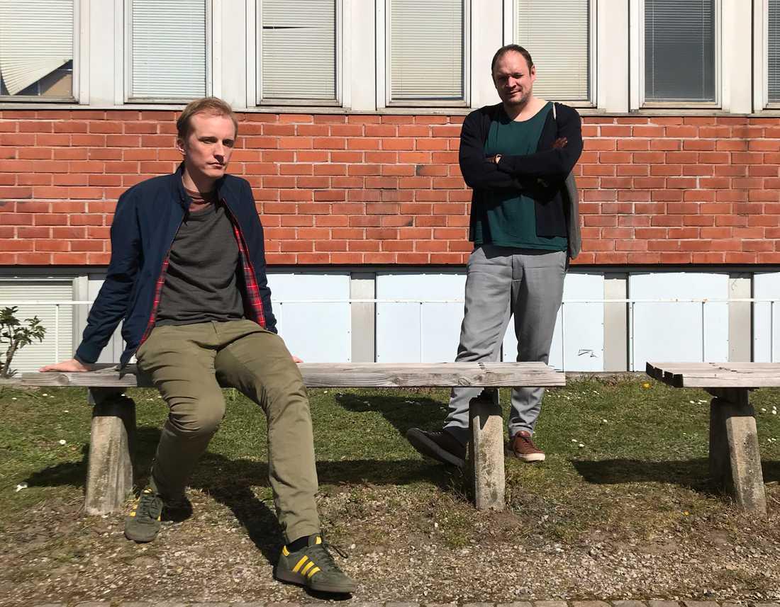 Veckans Stormen-värdar, Ola Söderholm och Jonathan Unge, kopplar av i solen framför en rustik tegelbyggnad. 