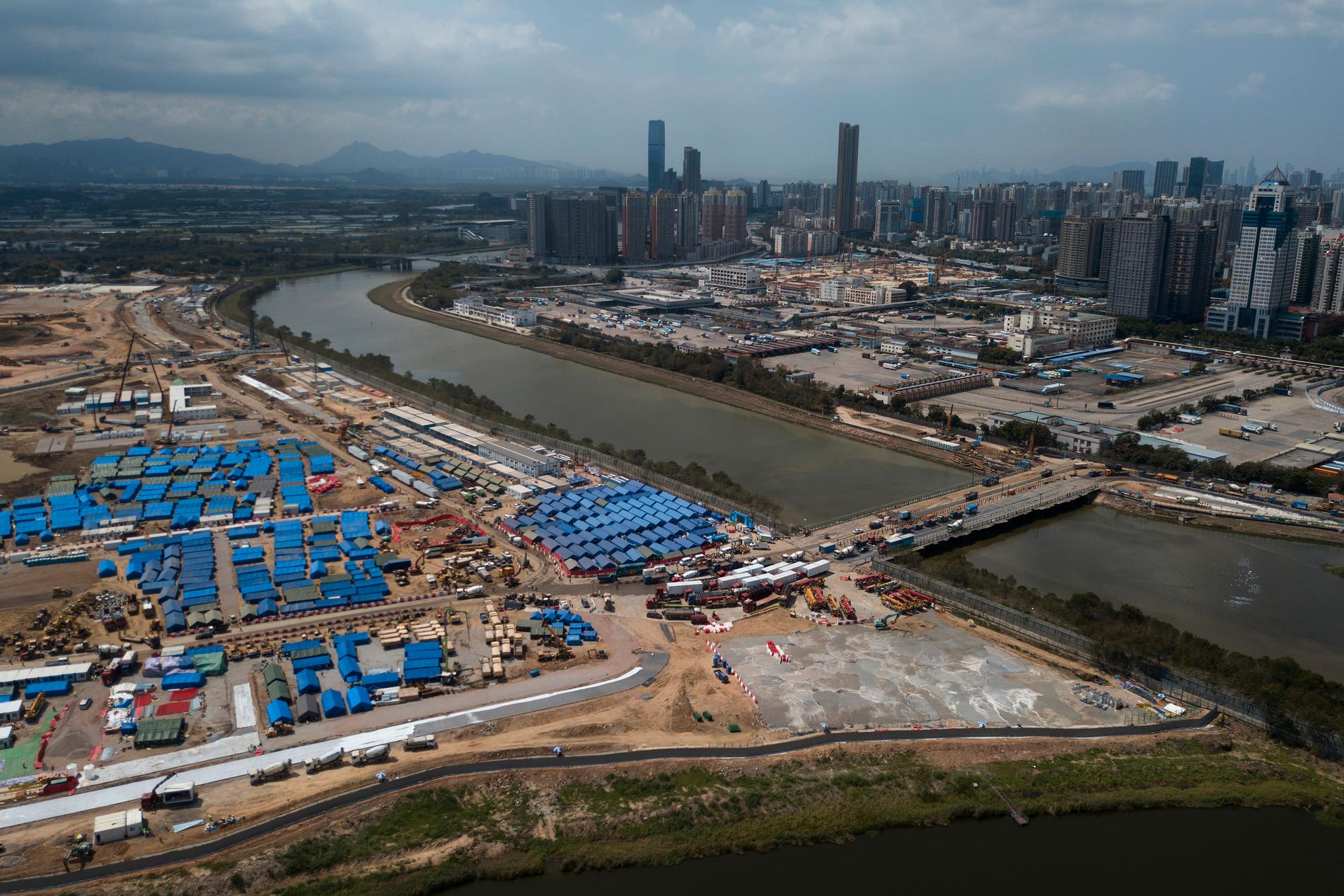 En flygvy över den tillfälliga bro som kopplar samman kinesiska Shenzhen med Hongkongs Lok Ma Chau. Här byggs nu nya isoleringsanläggningar för covid-19.