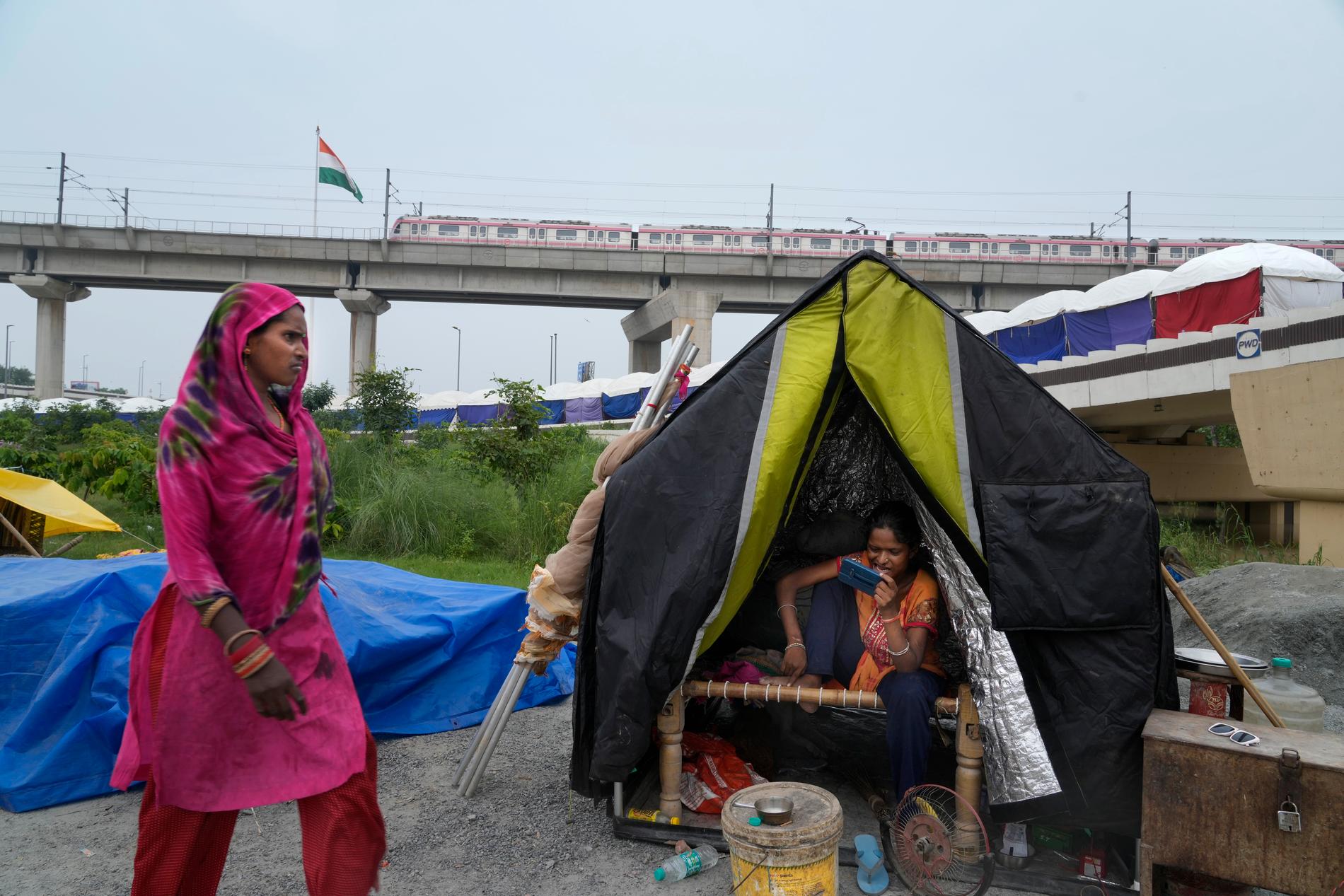 Den översvämmade Jamunafloden tvingar människor att lämna sina hem i New Delhi och upprätta tillfälliga boenden.