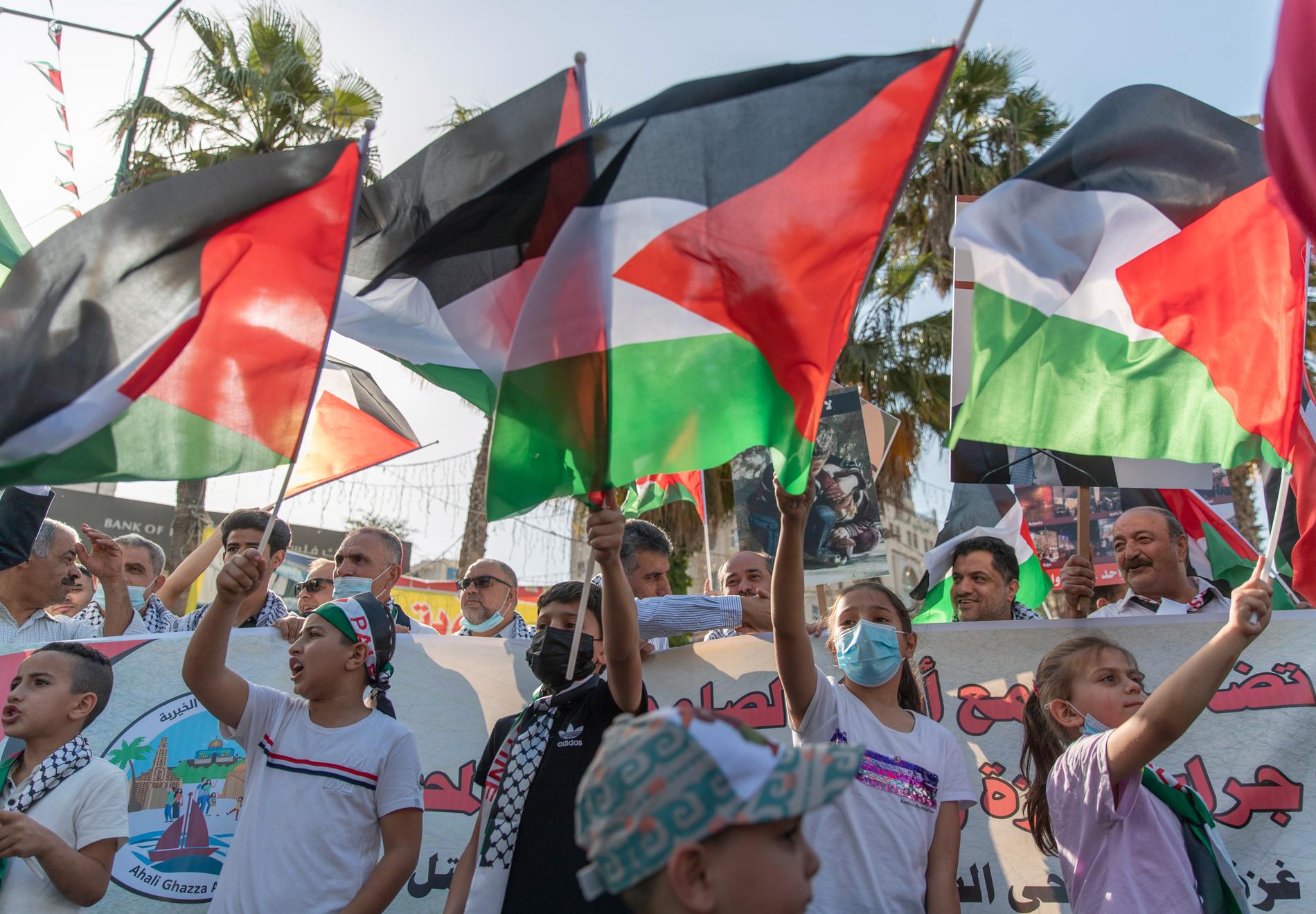 Barn viftar med palestinska flaggor i en demonstration till stöd för Gazas folk i staden Ramallah på Västbanken. Arkivbild.
