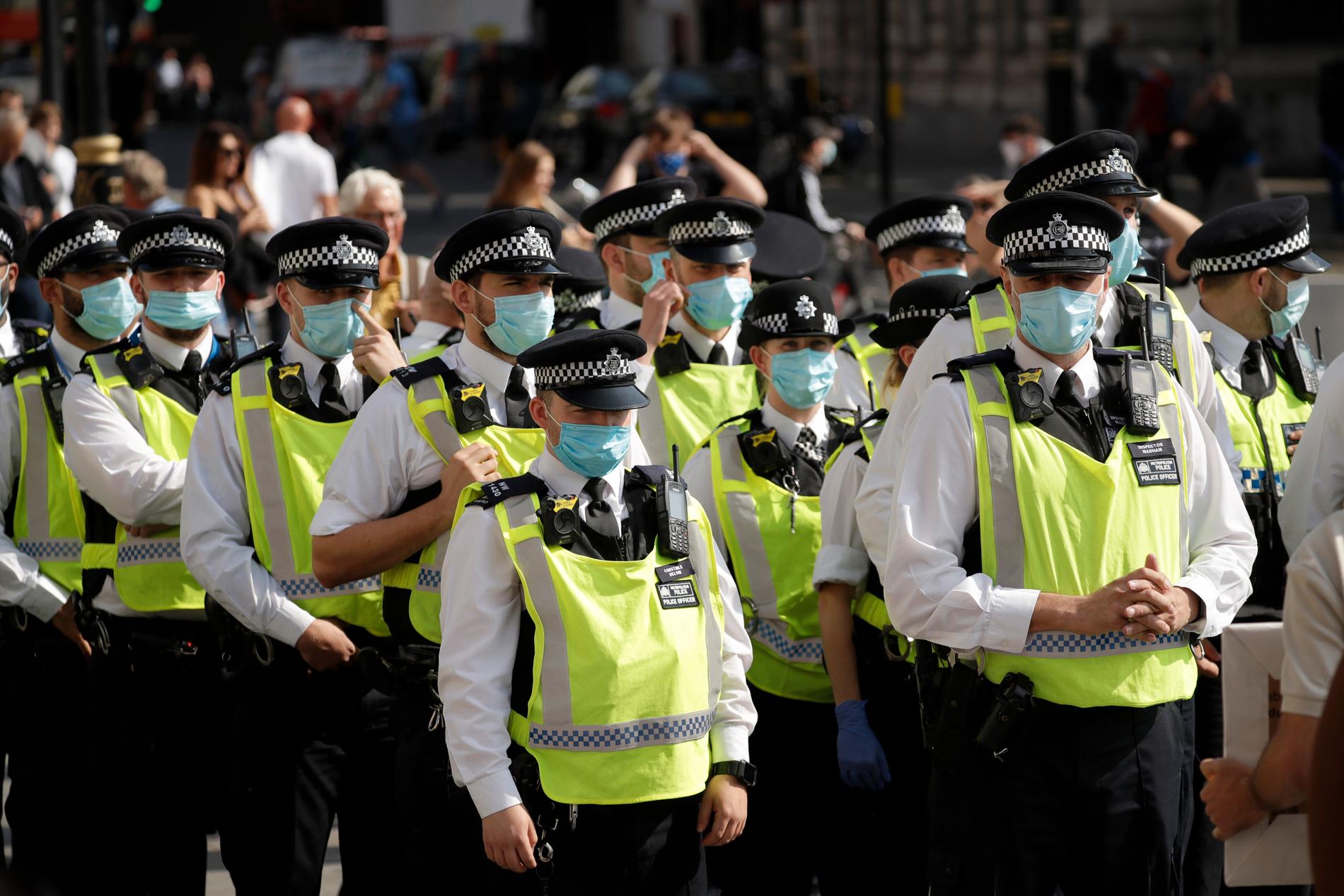 Poliser i masker vid protesterna på Trafalqar square.