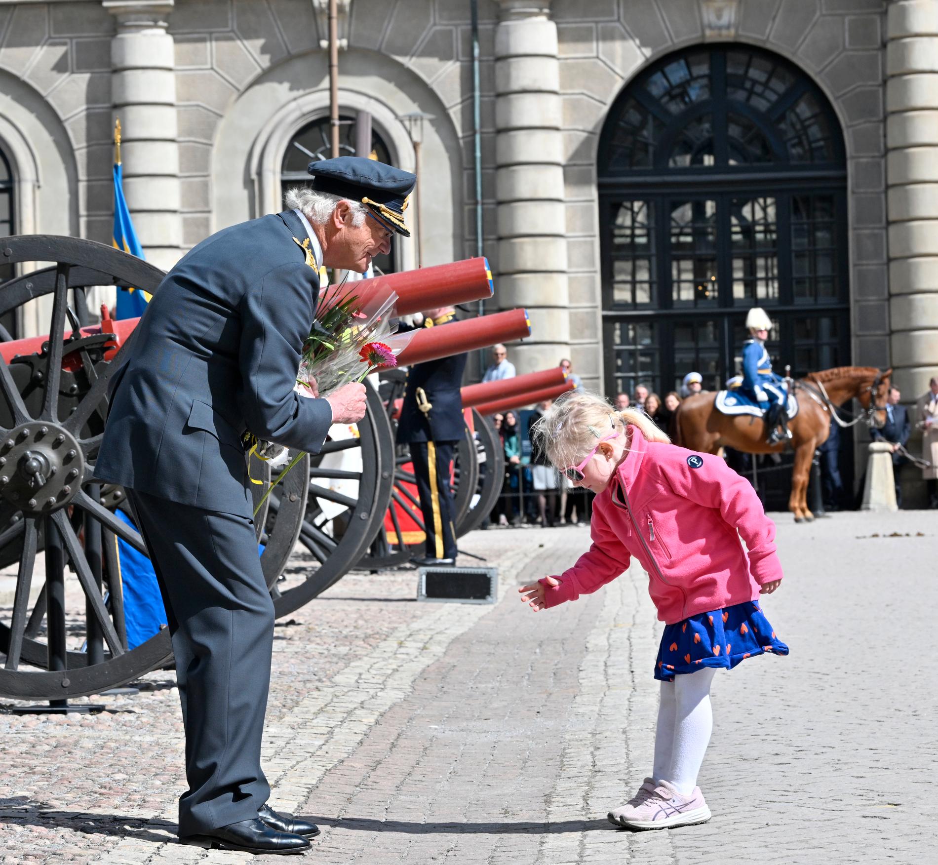 Kung Carl XVI Gustaf blir uppvaktad med blommor av barn vid firandet av kungens födelsedag på Stockholms slott på lördagen.