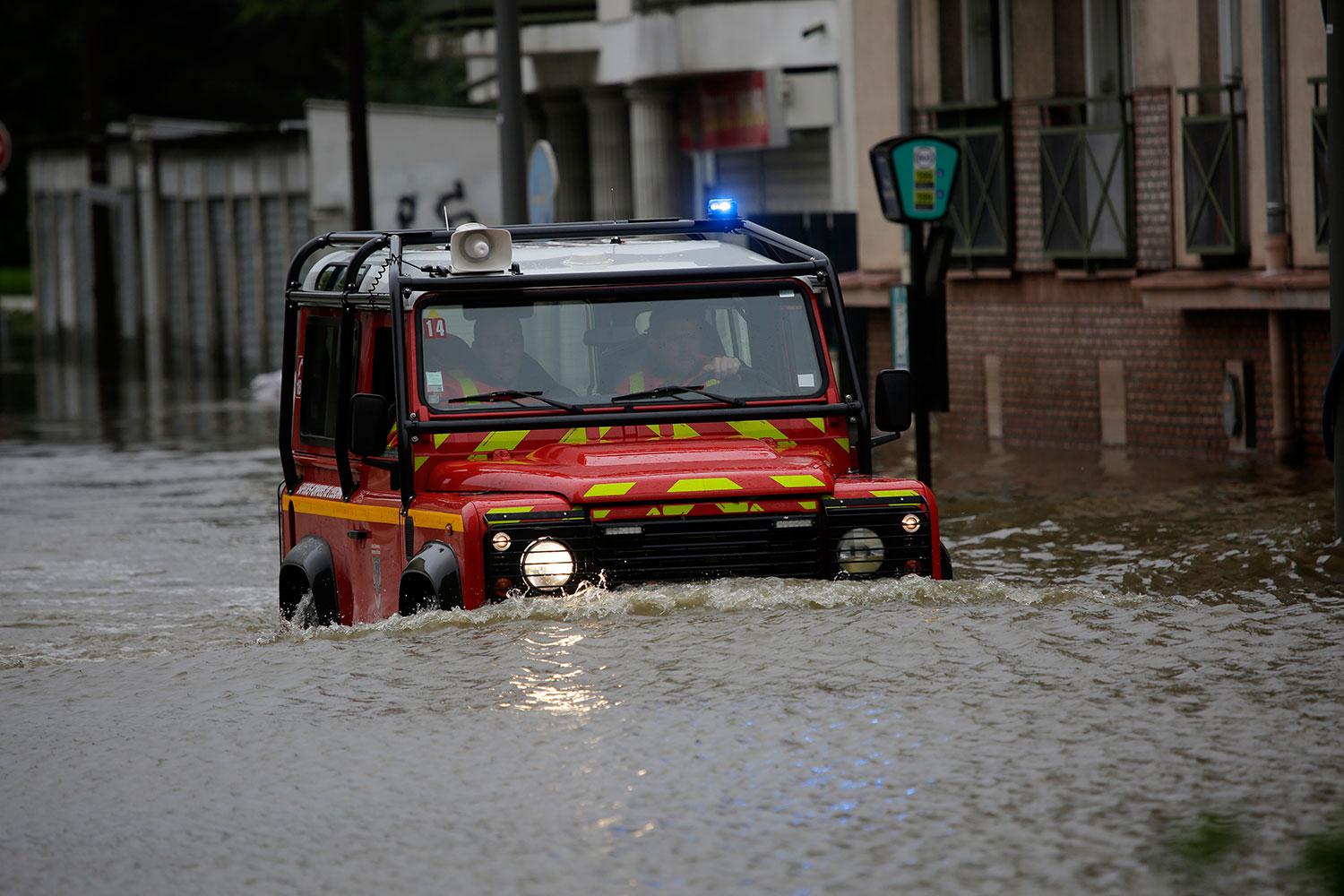 En bil från räddningstjänsten försöker ta sig fram i Longjumeau, söder om Paris.
