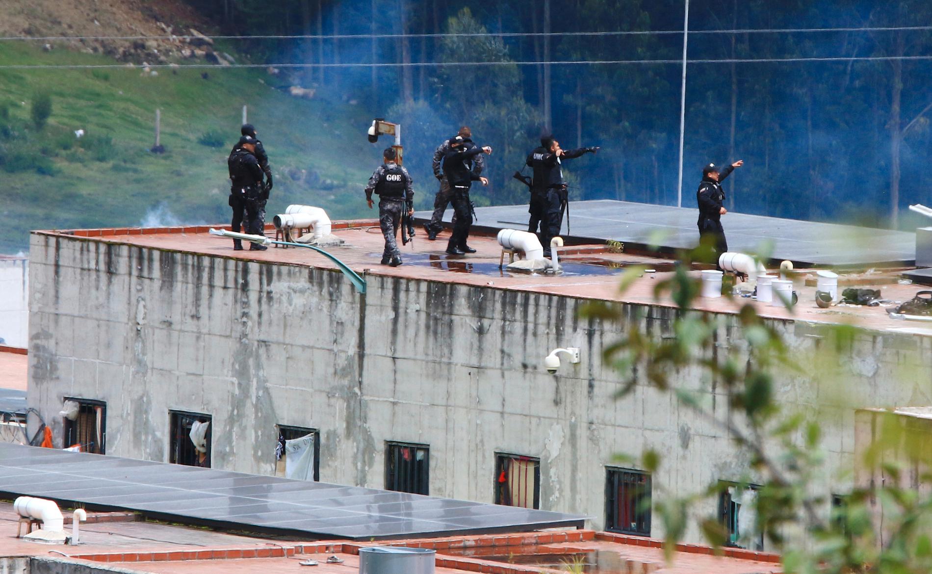 Poliser på taket till fängelset El Turi i Cuenca där ett stort bråk utbröt på söndagen.