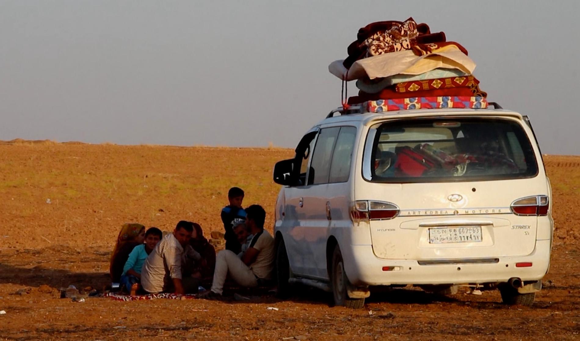 Familj har flytt bombningarna och pausar i staden Kobani innan reser vidare mot gränsen för att söka skydd. 