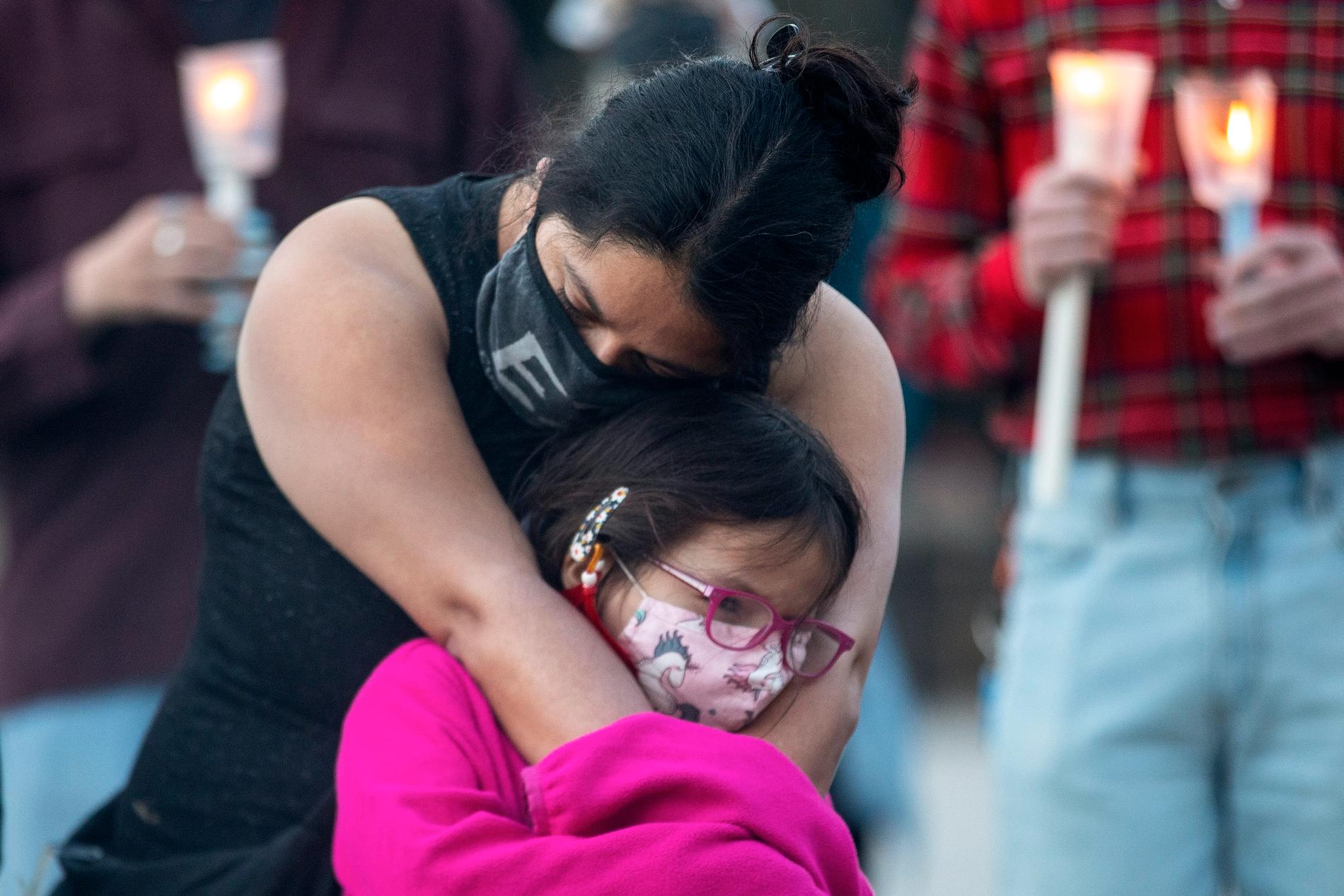 En mamma kramar om sin dotter vid en minnesceremoni i Toronto på söndagen.