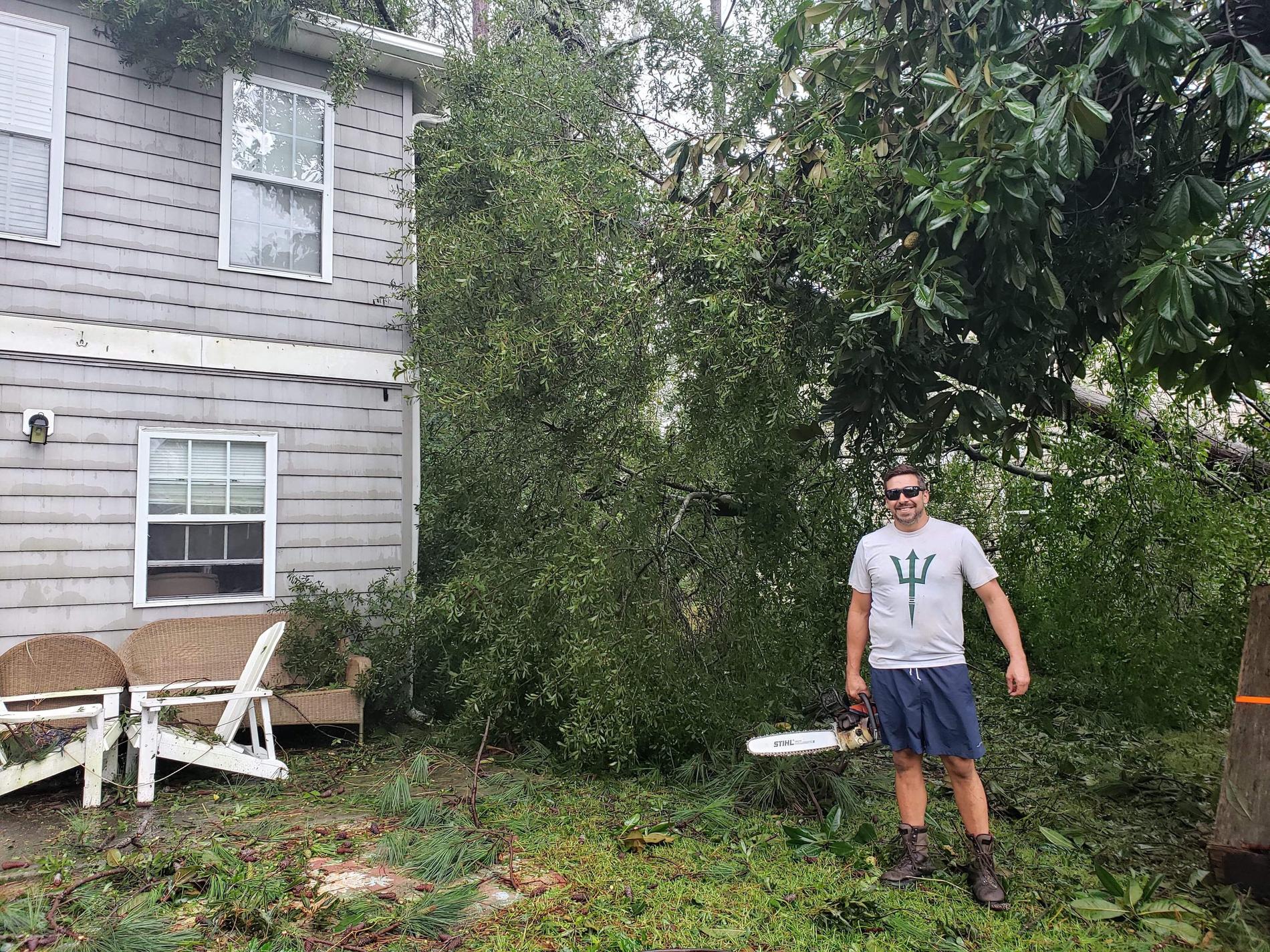 Jeremy Tominack är ute med motorsågen för att hjälpa grannar vars hus fått träd över sig.